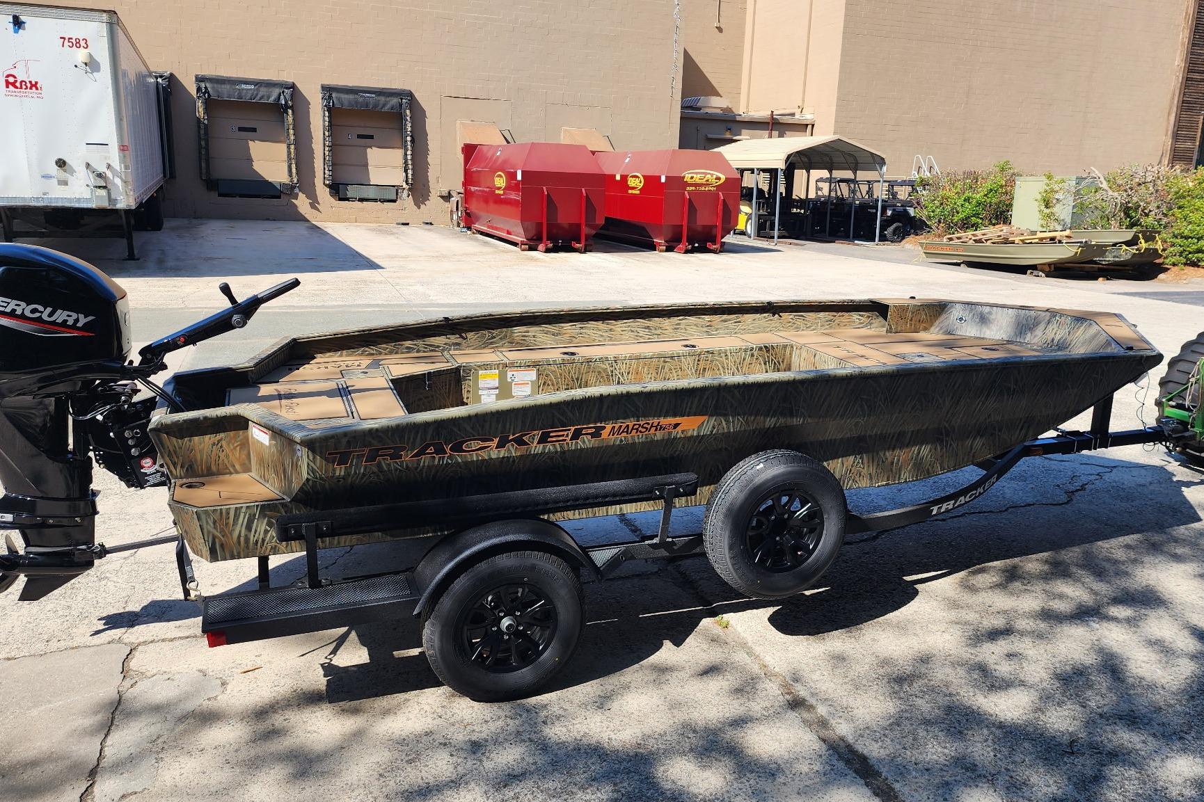 2026 Tracker Grizzly 1756 T Marsh boat on trailer, parked outdoors in industrial area.