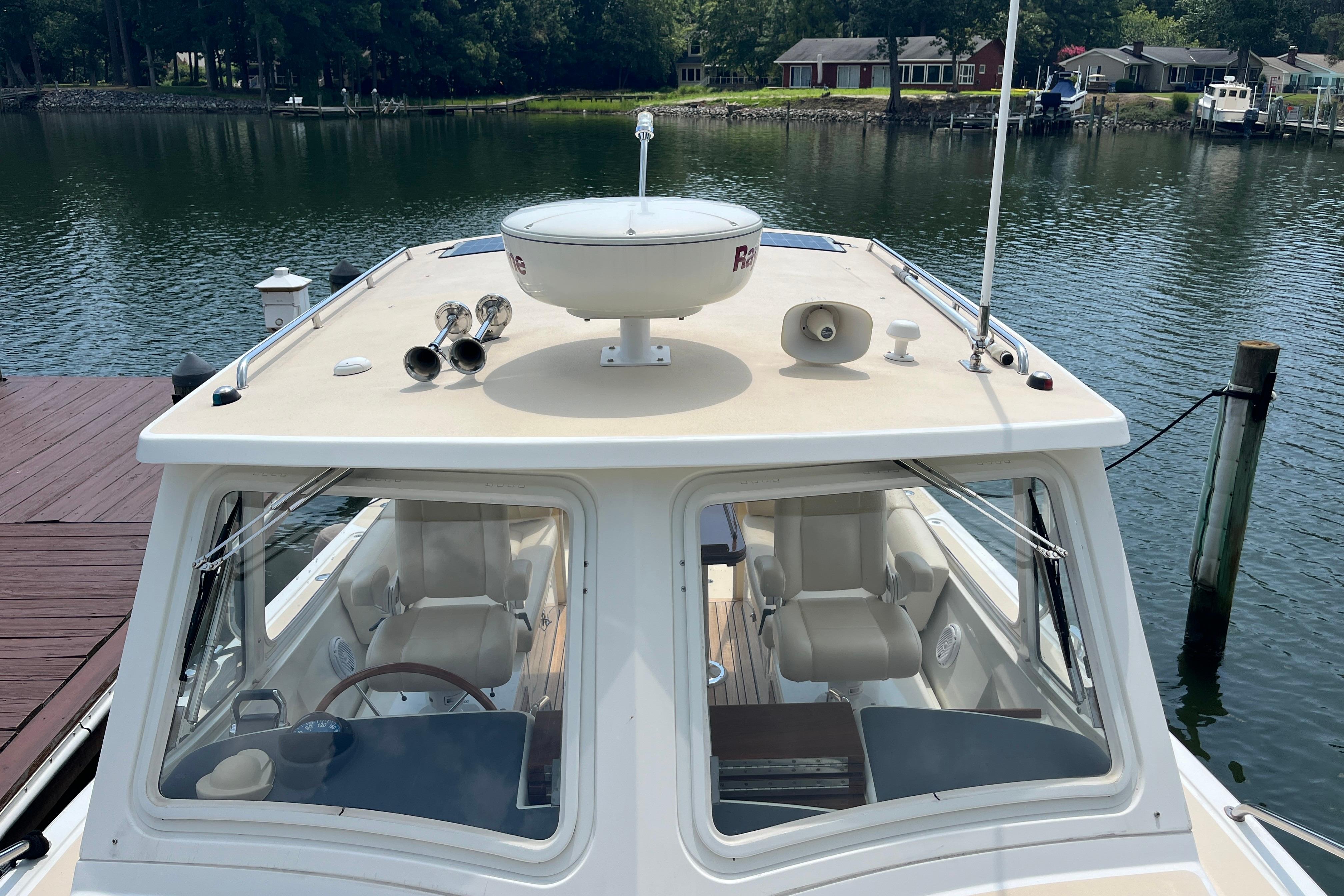 2006 MJM 34z boat docked on calm water, showcasing cockpit and radar equipment.