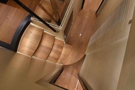 Modern wooden staircase in 2022 Horizon PC65 yacht interior.