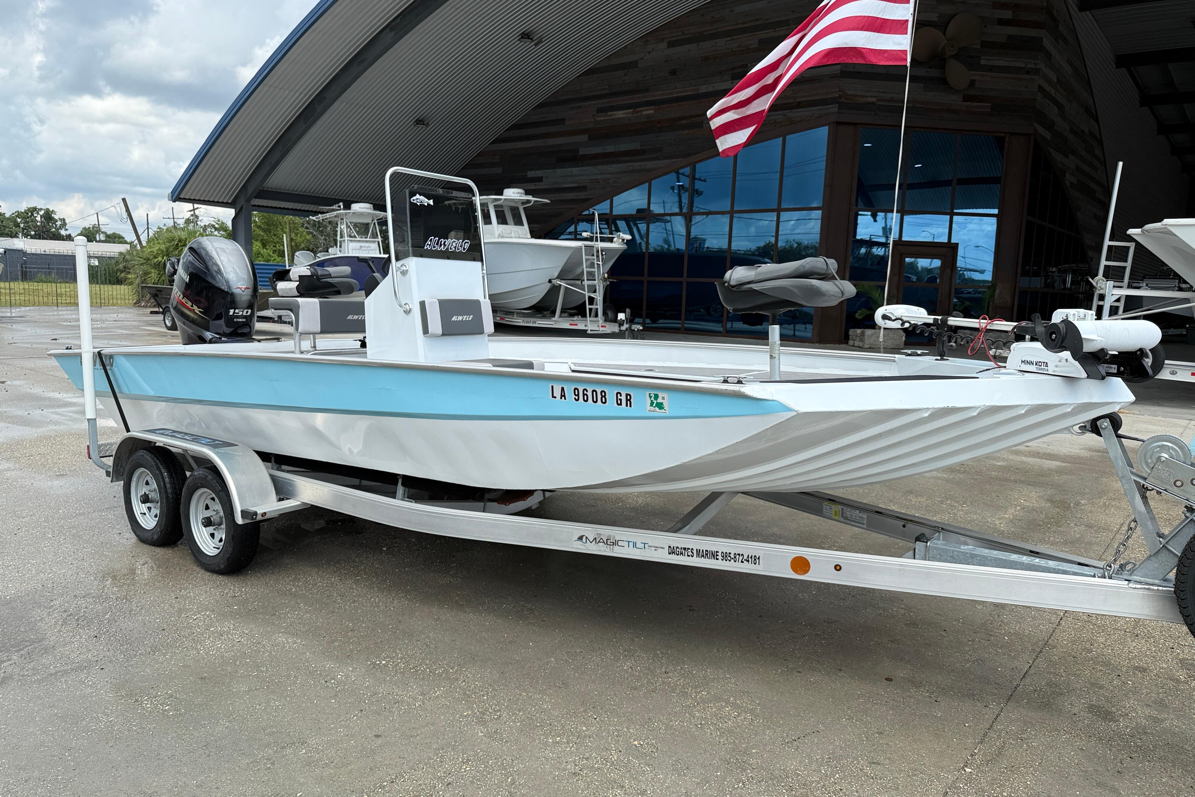 2024 Alweld 2070cc boat on trailer, displayed outdoors with American flag.