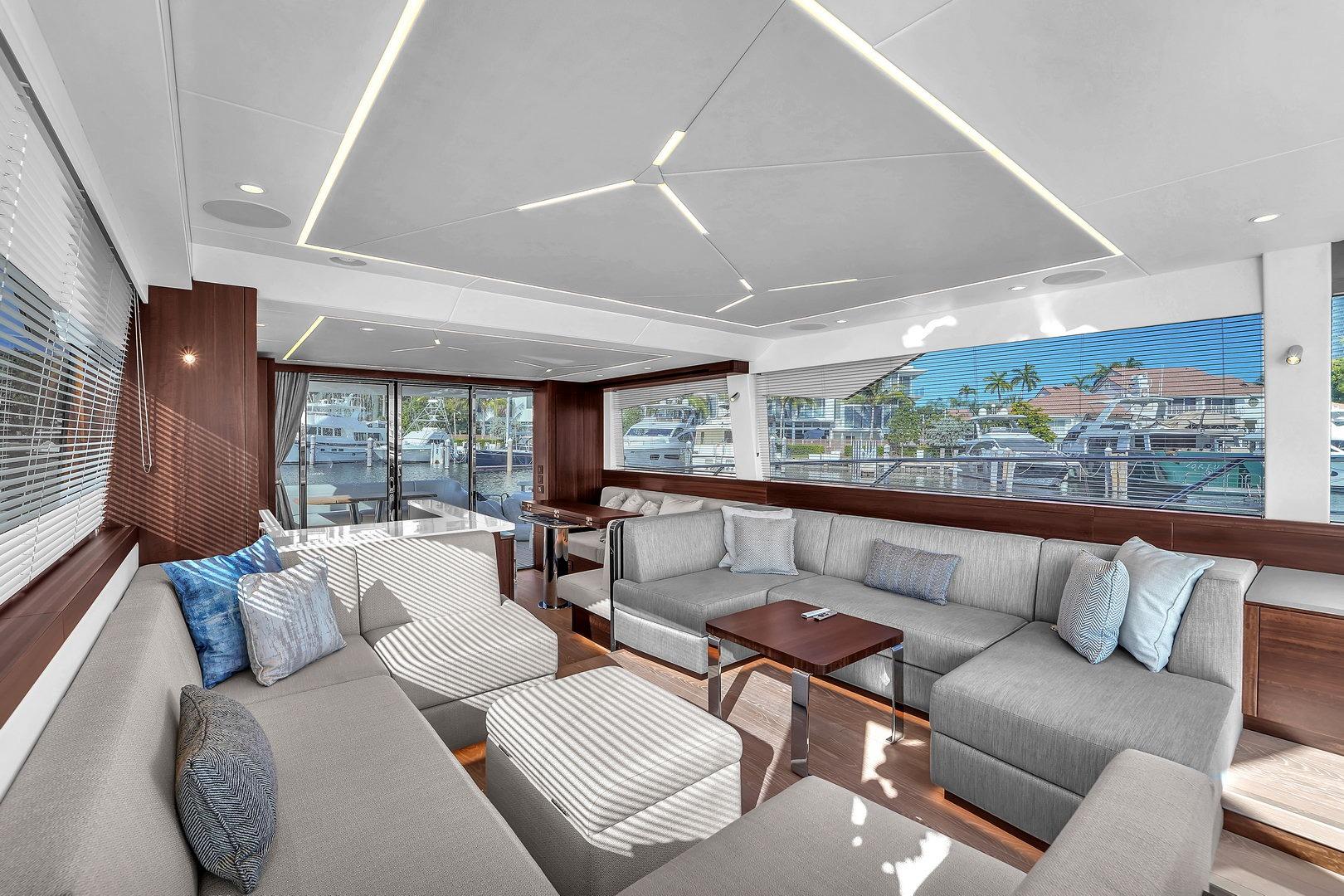 Luxurious interior of 2023 Sunseeker Manhattan 68 yacht with modern seating and large windows.
