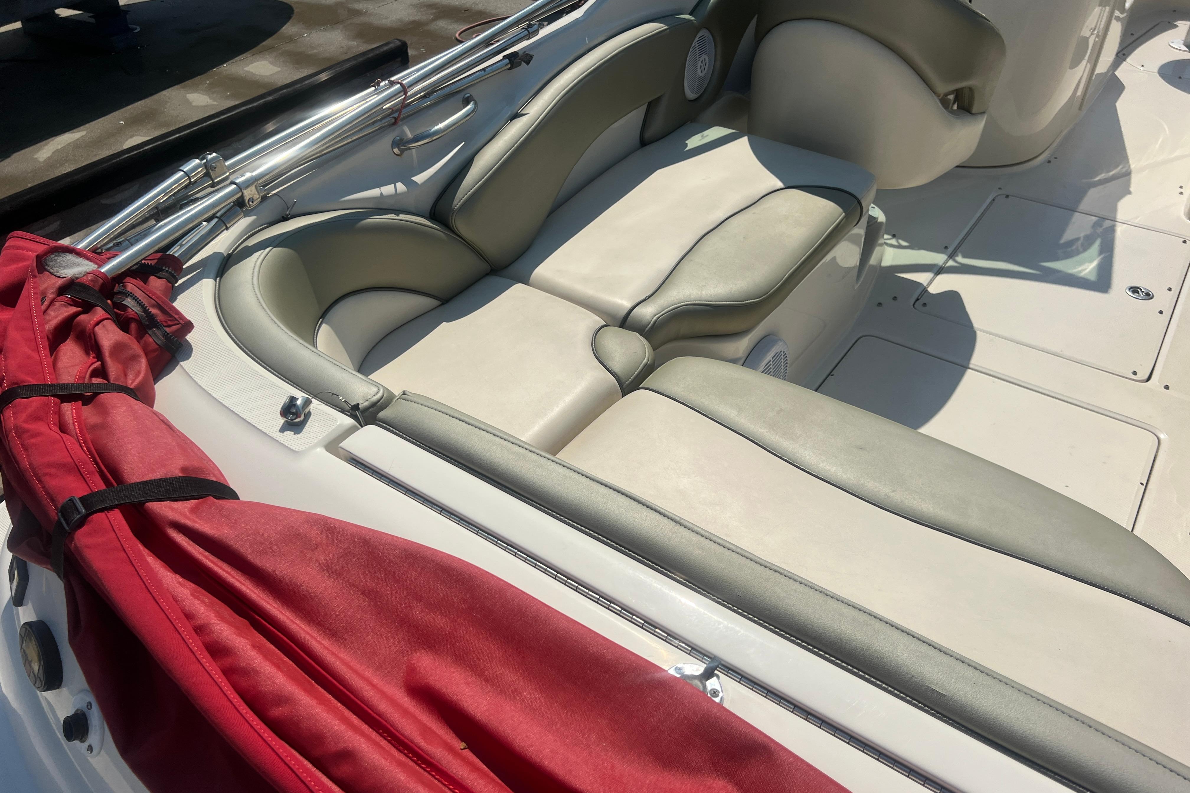2005 Sea Ray 240 Sundeck interior with beige seating and red cover.