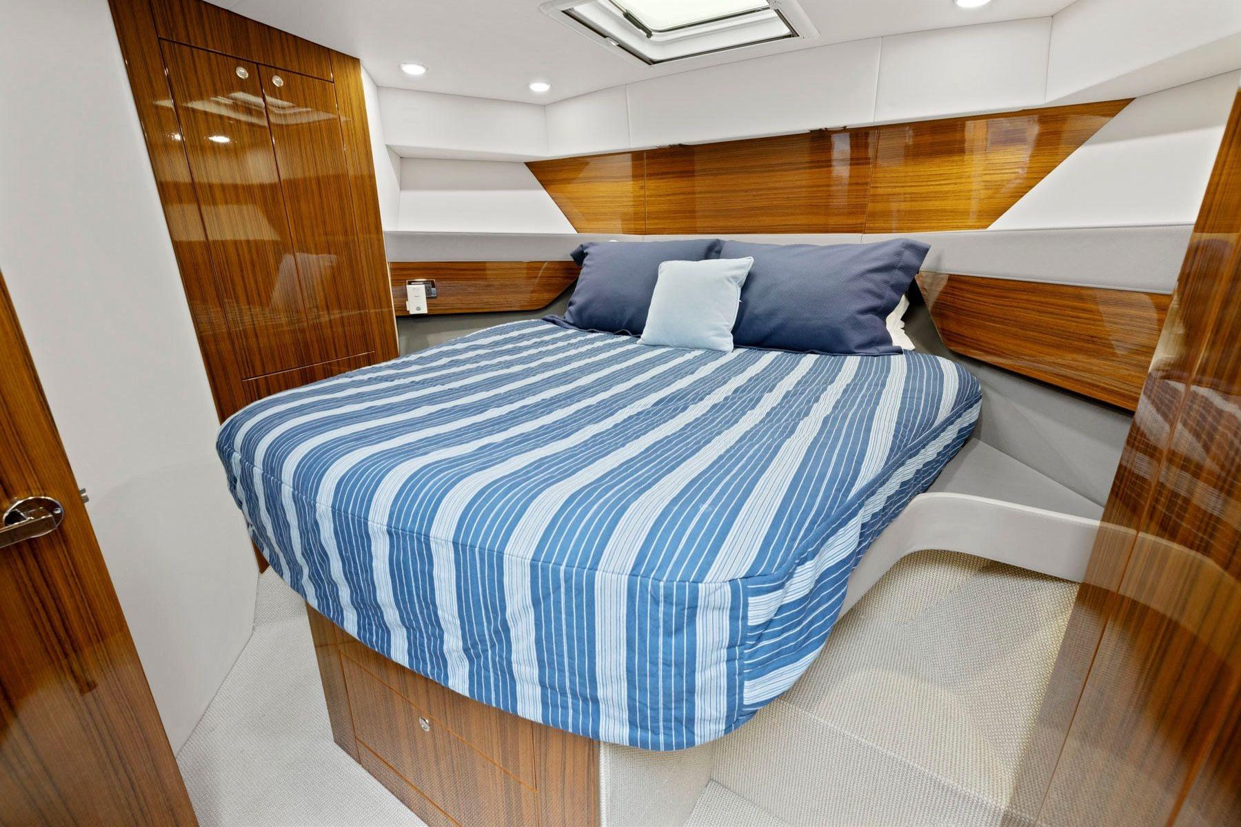 Luxurious cabin interior of 2014 Maritimo M50 yacht with striped bedding.