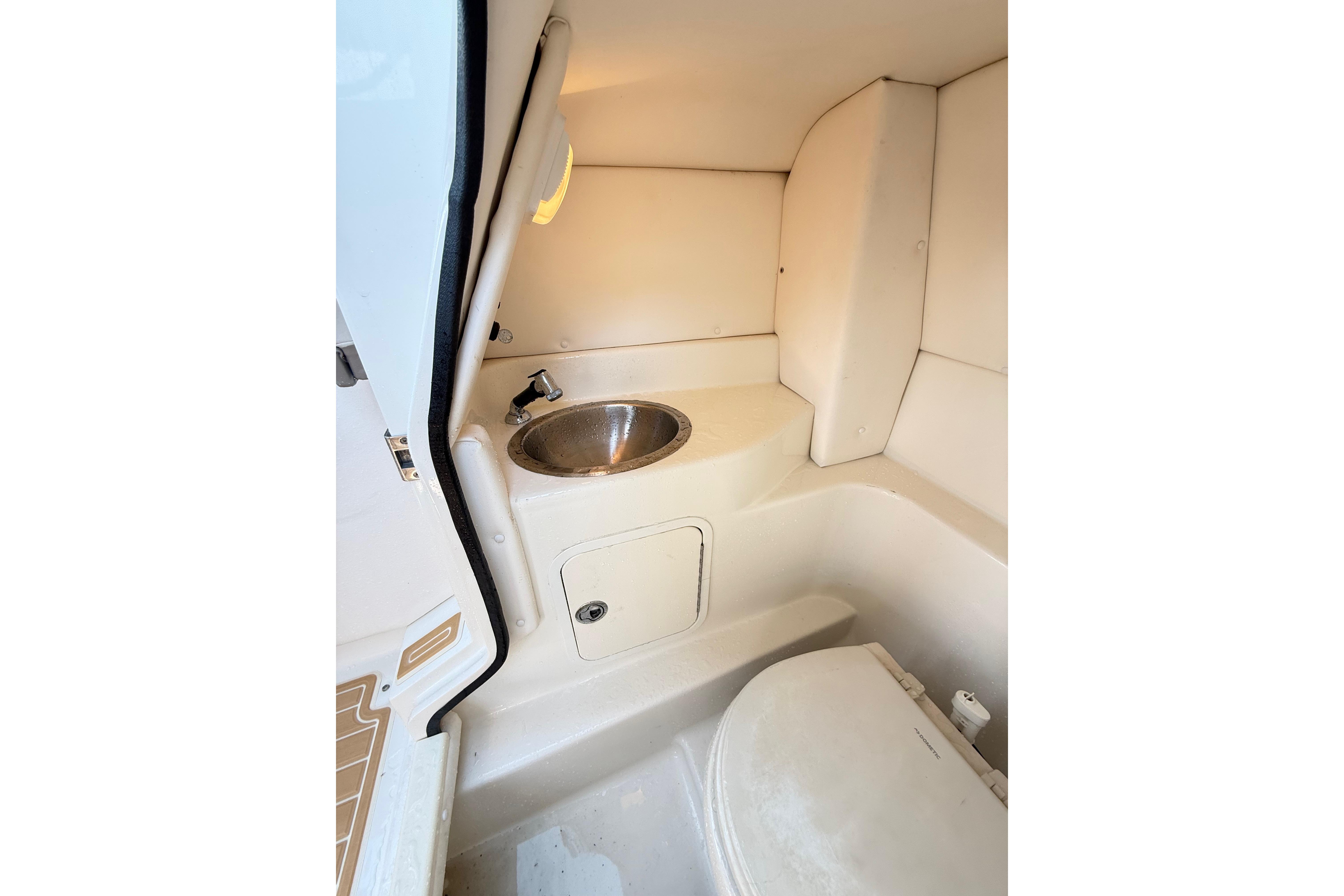 Interior of 2011 Sea Ray 270 SLX boat featuring compact bathroom amenities.