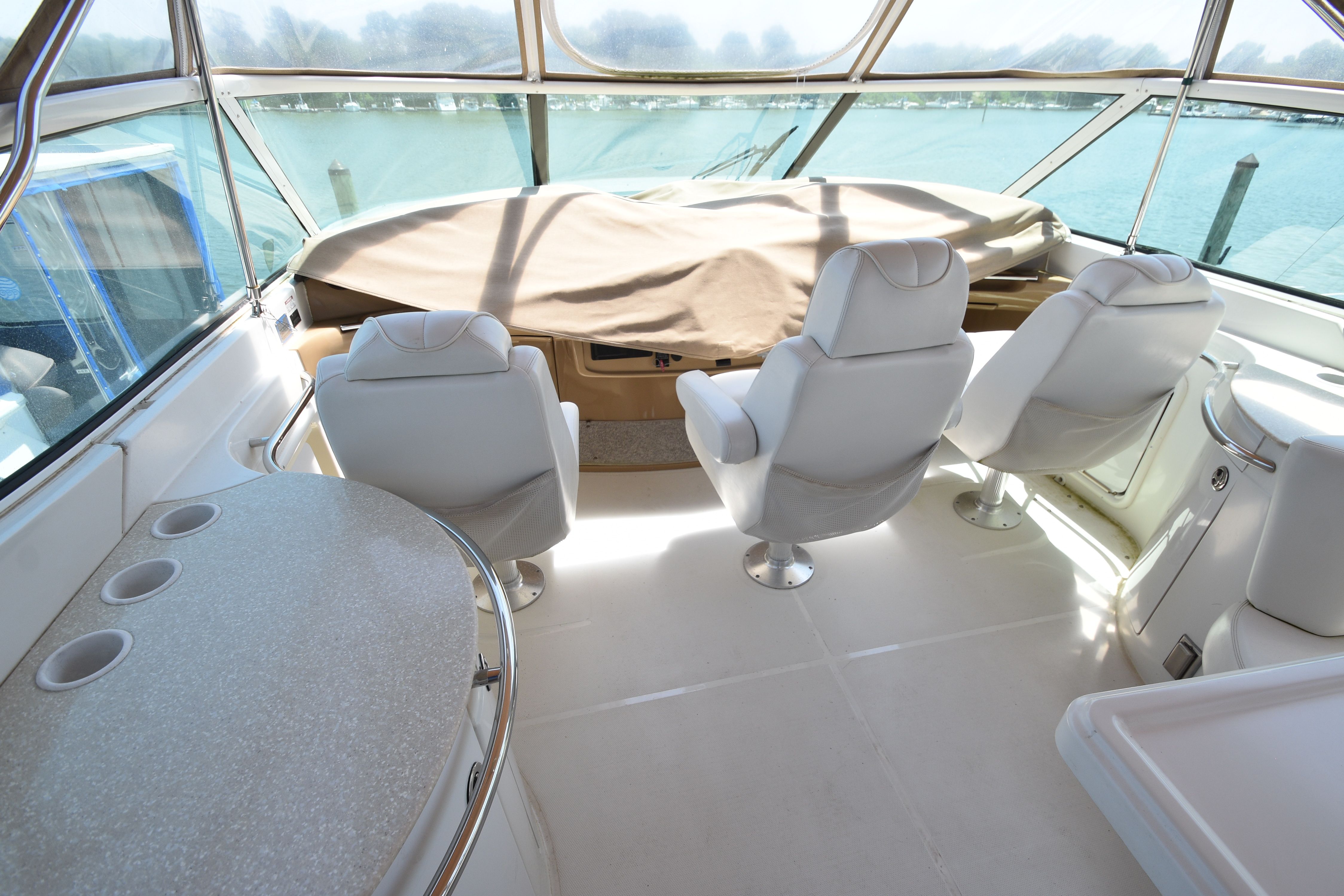 The image shows the cockpit of a 2004 Carver 466 Motor Yacht with white seats.