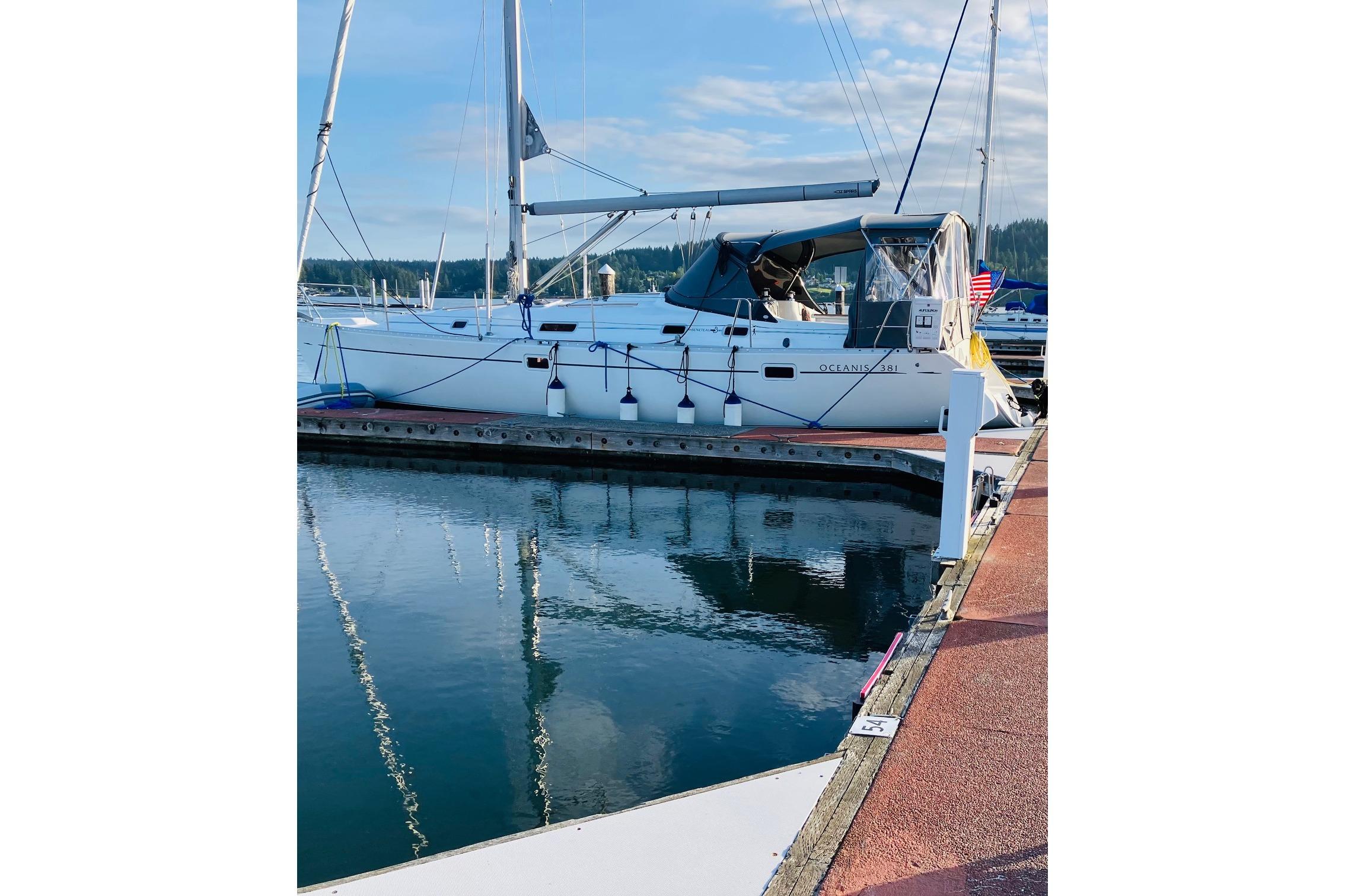 1998 Beneteau 381 sailboat docked at marina, reflecting on calm water.