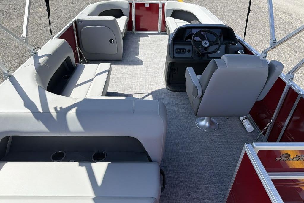 2026 Sun Tracker Party Barge 18 DLX interior with gray seating and steering console.