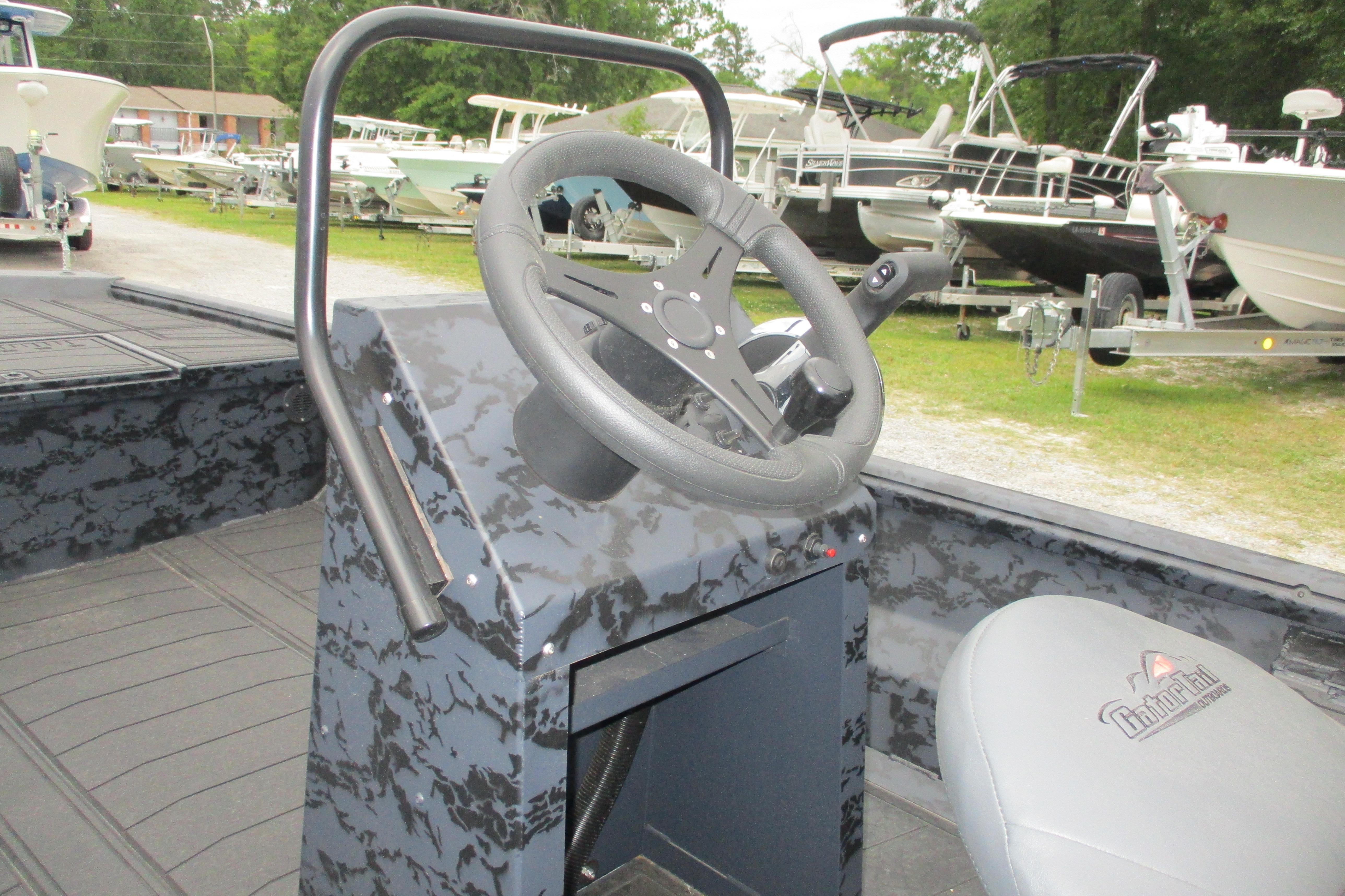 2026 Gator Tail 1860 Extreme CC boat steering console with camouflage design in a marina setting.
