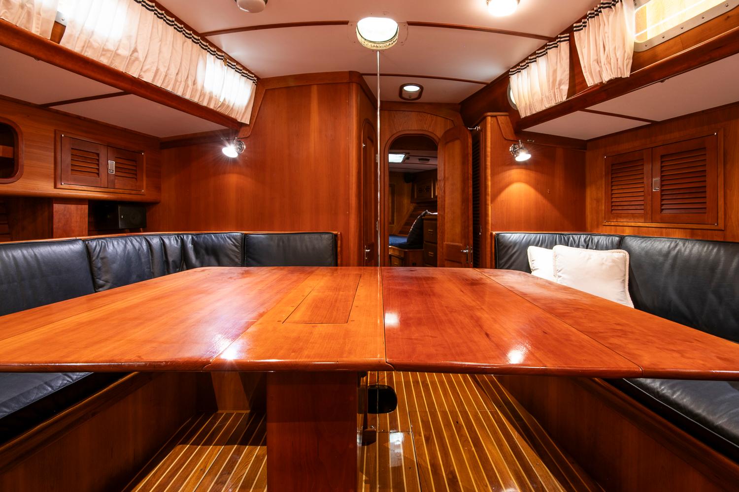 Luxurious wooden interior of 1993 Hinckley Sou'wester 51 yacht with elegant seating and lighting.