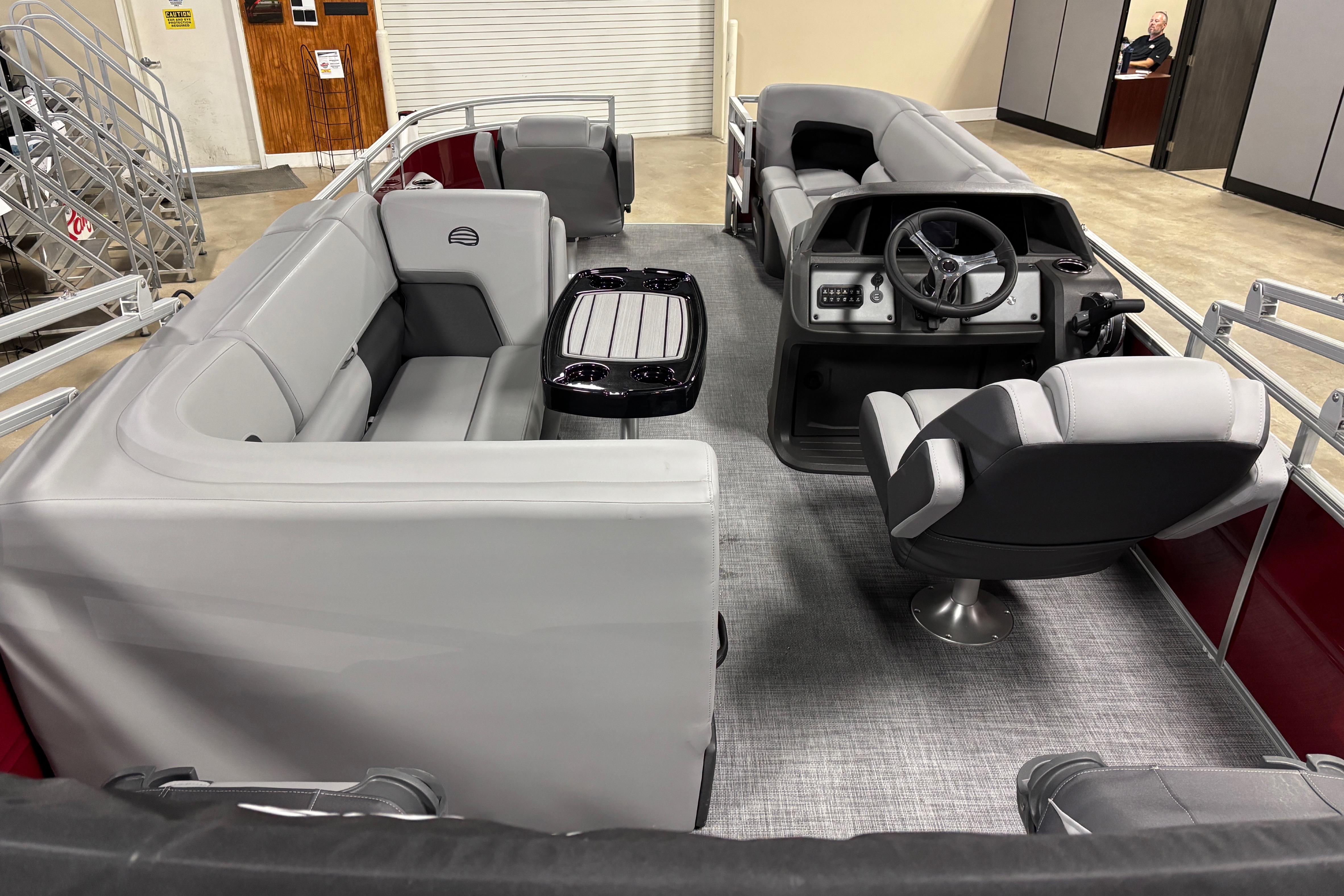 2026 Sun Tracker SportFish 20 DLX pontoon boat interior with gray seating and steering console.