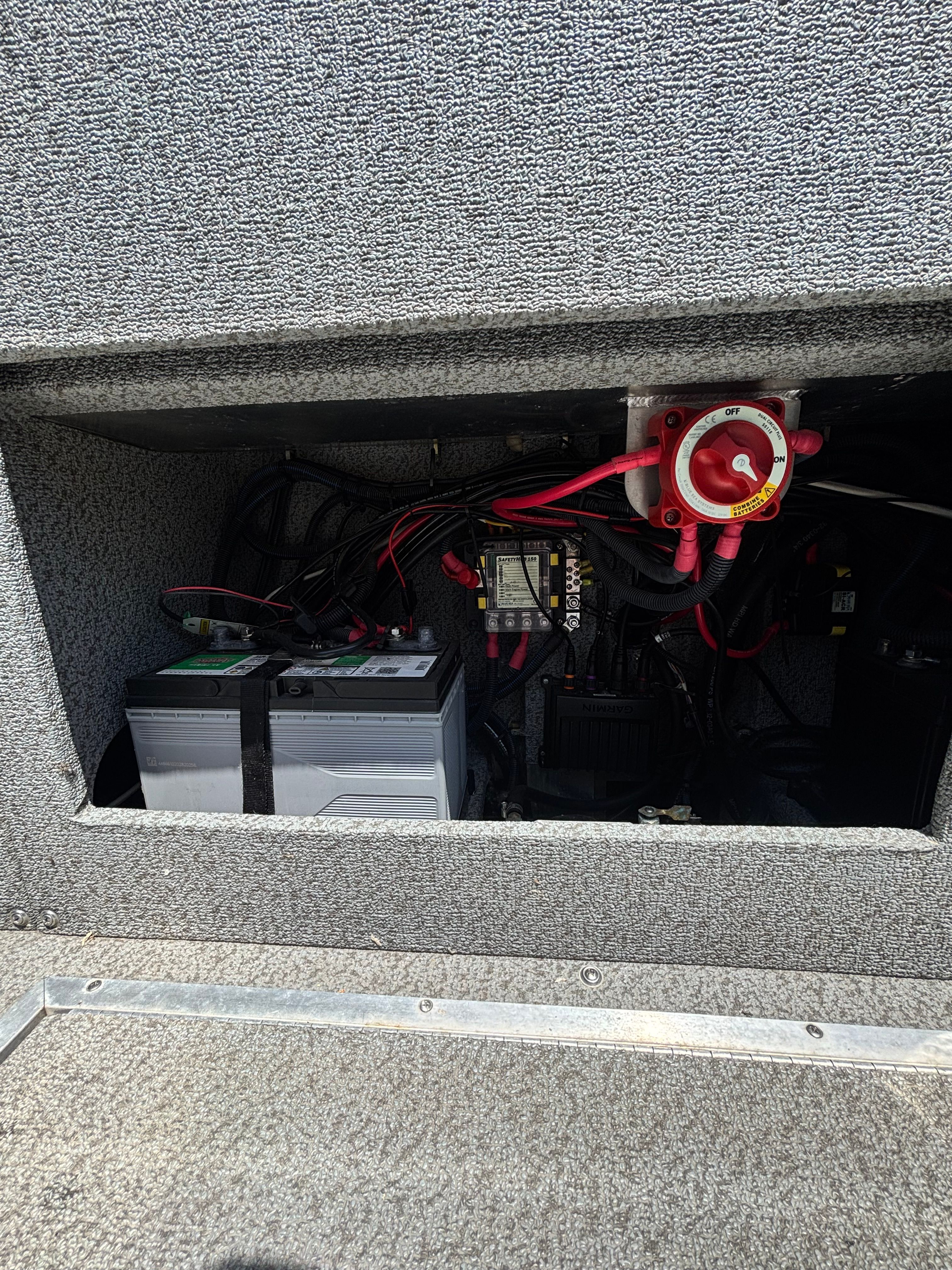 Boat battery compartment with two batteries and wiring.
