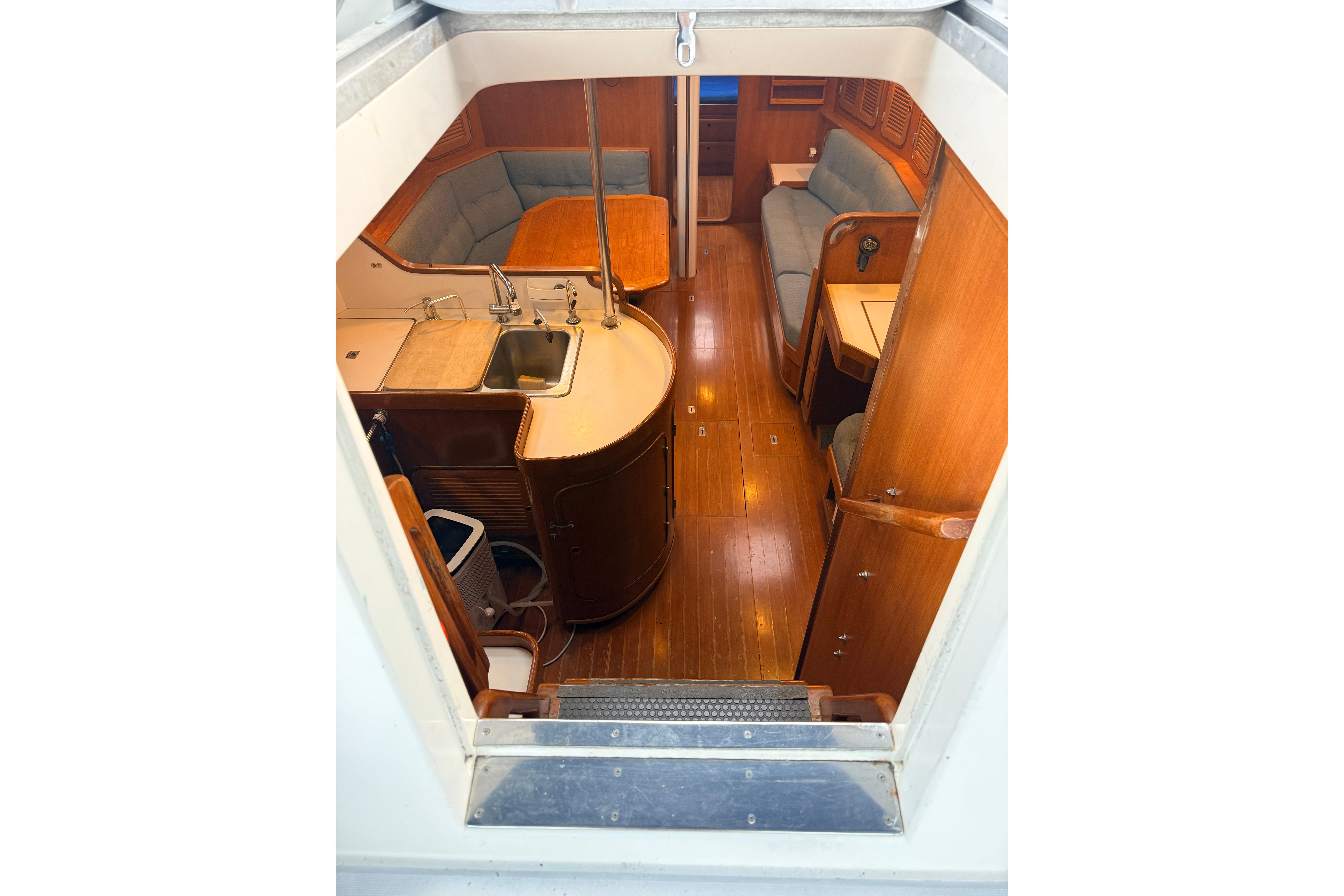 Interior view of 1987 Norseman 400 sailboat, featuring wooden cabinetry and seating area.