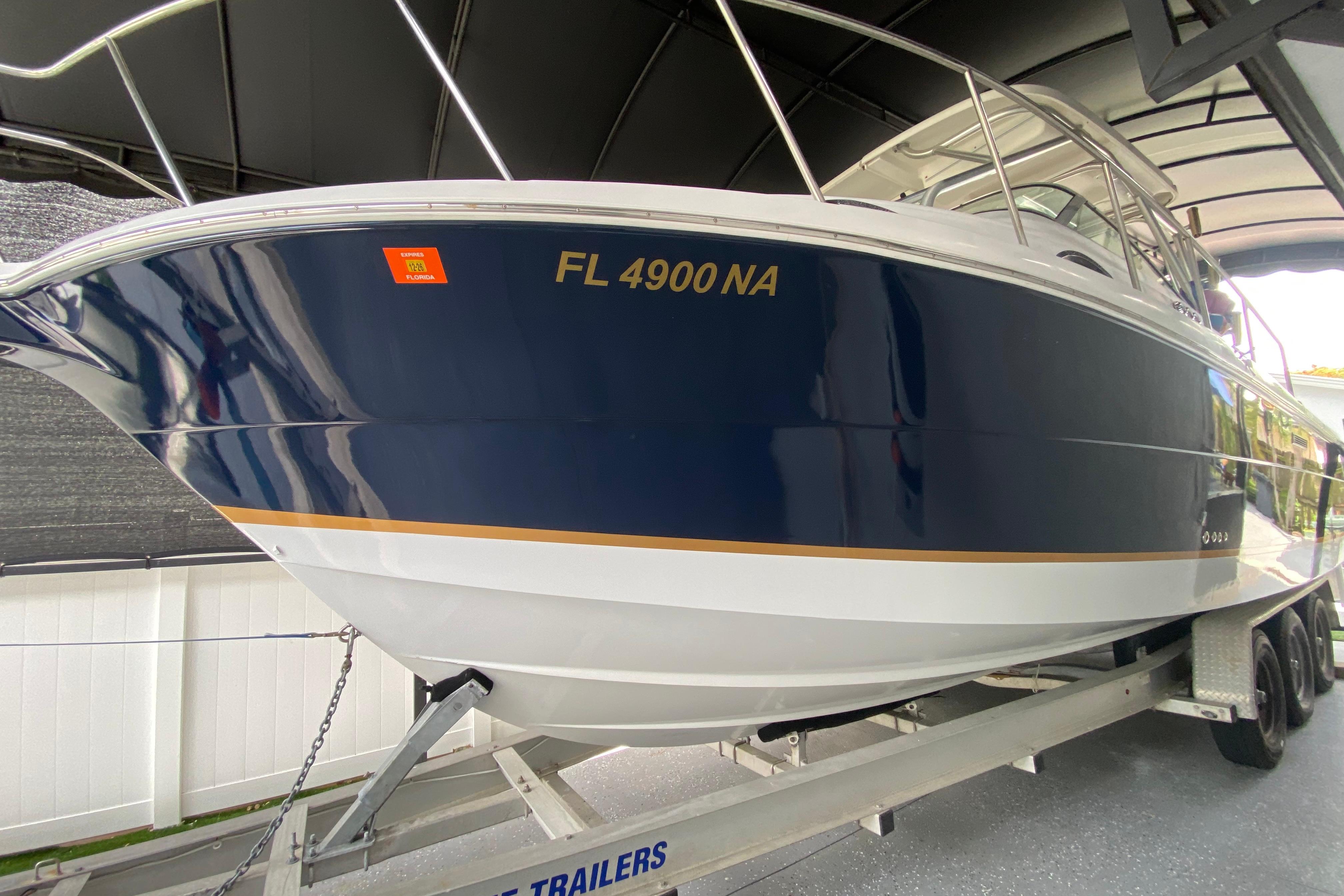 2005 Wellcraft 290 Coastal boat on trailer, blue hull, registration FL 4900 NA.