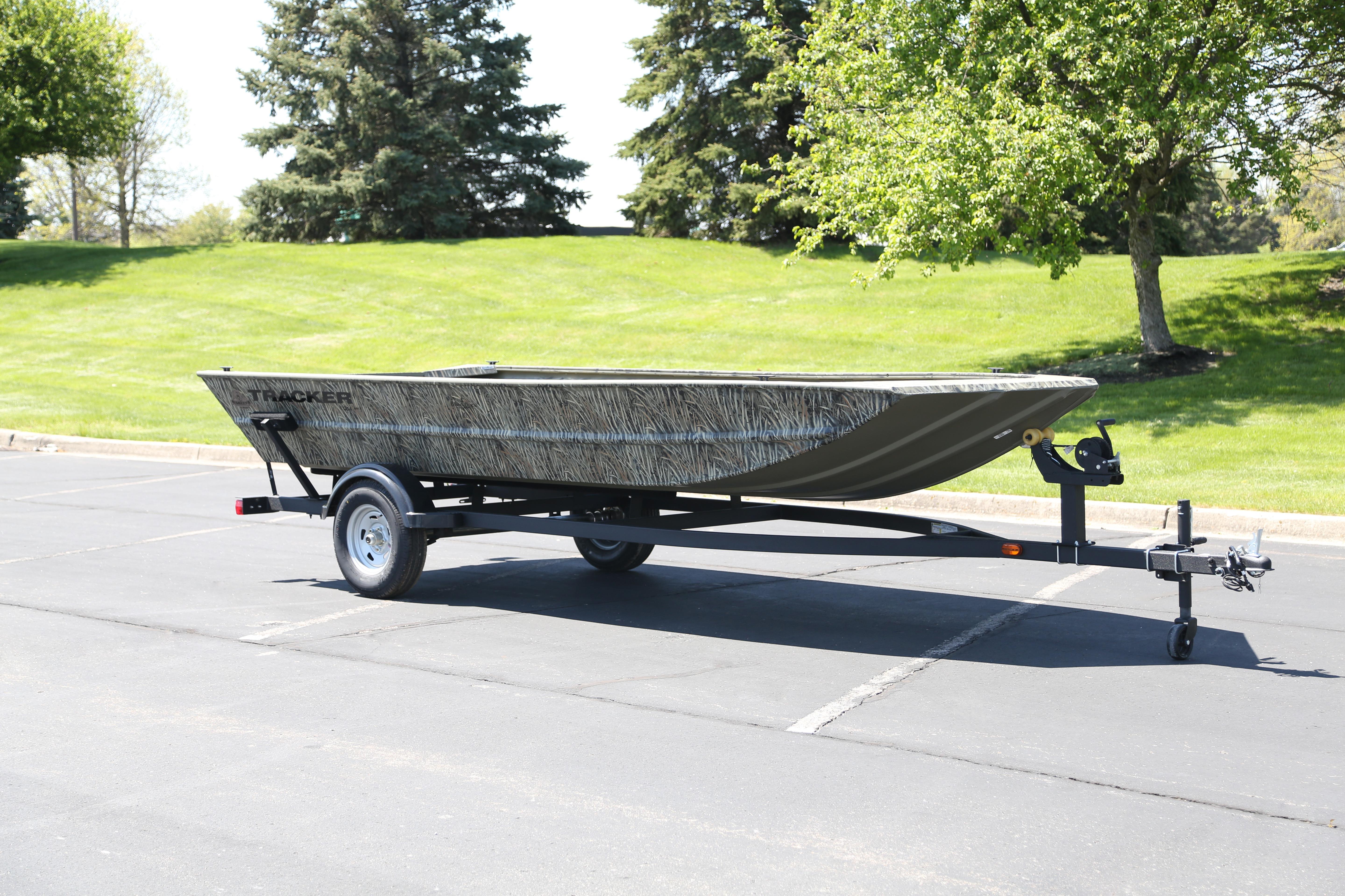 2026 Tracker Grizzly 1754 Utility boat on trailer in sunny park setting.