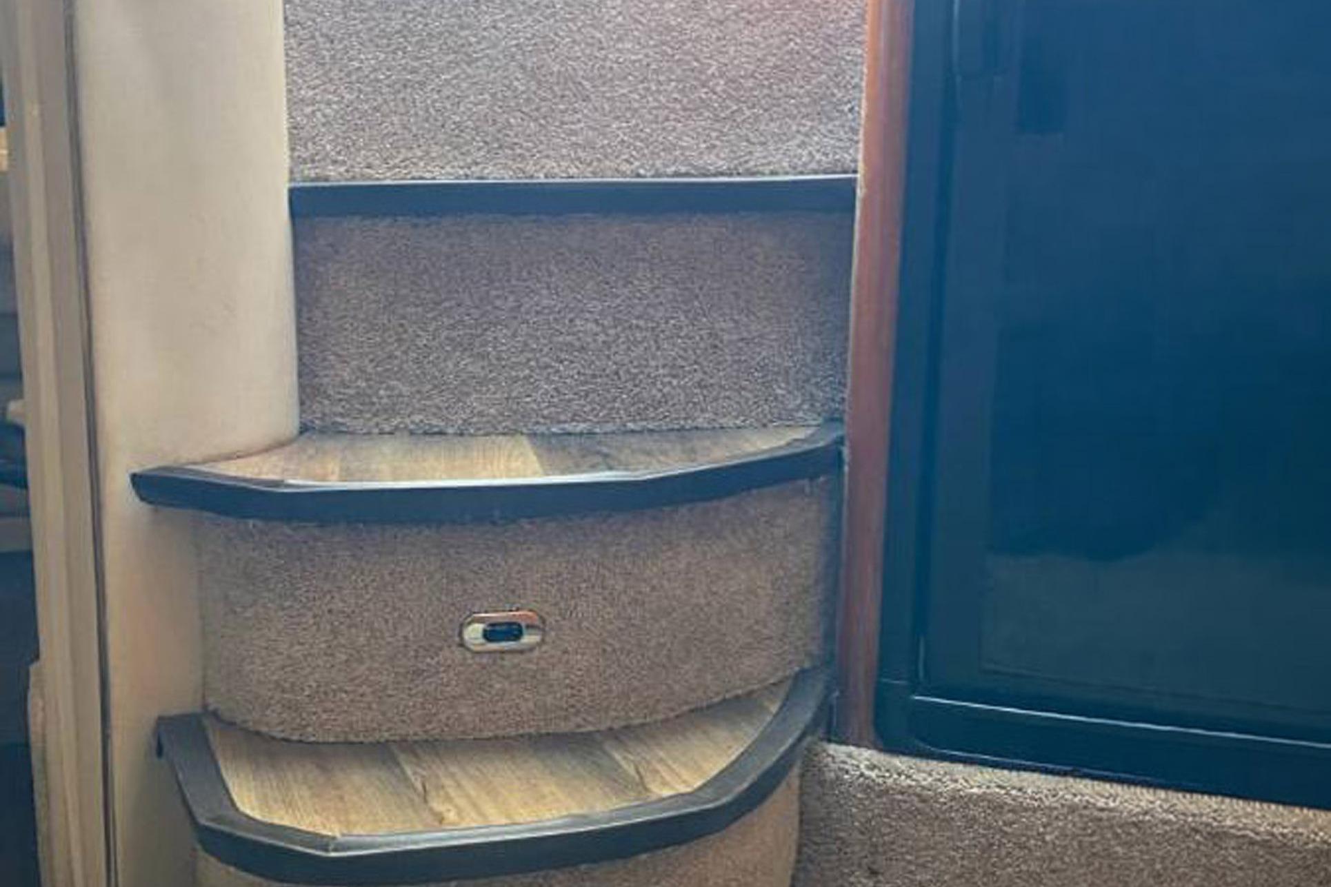 Carpeted stairs inside a 1998 Sea Ray Sundancer 400 yacht.