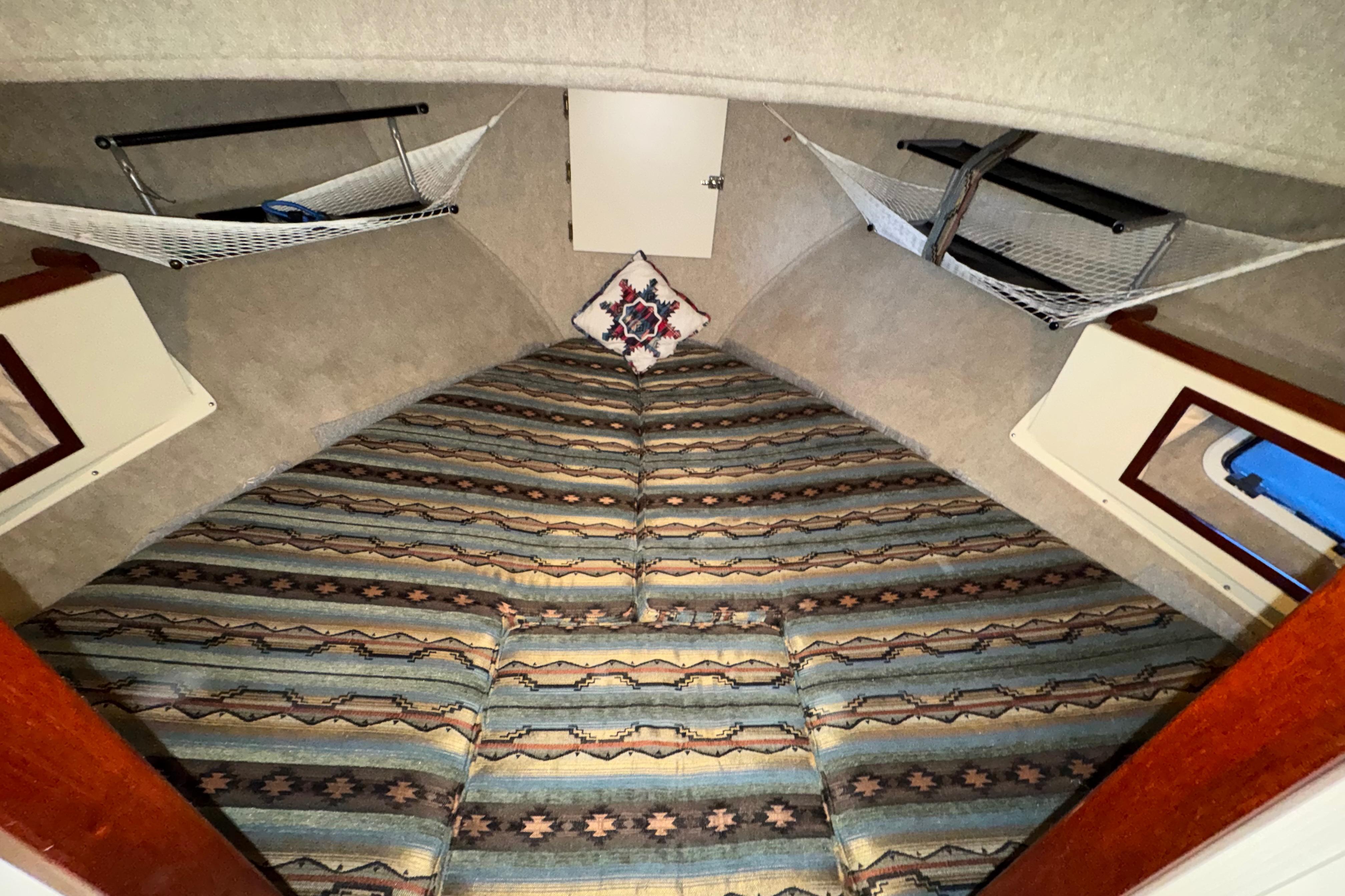 Interior of 2004 Camano 31 Troll boat with patterned bedding and storage hammocks.