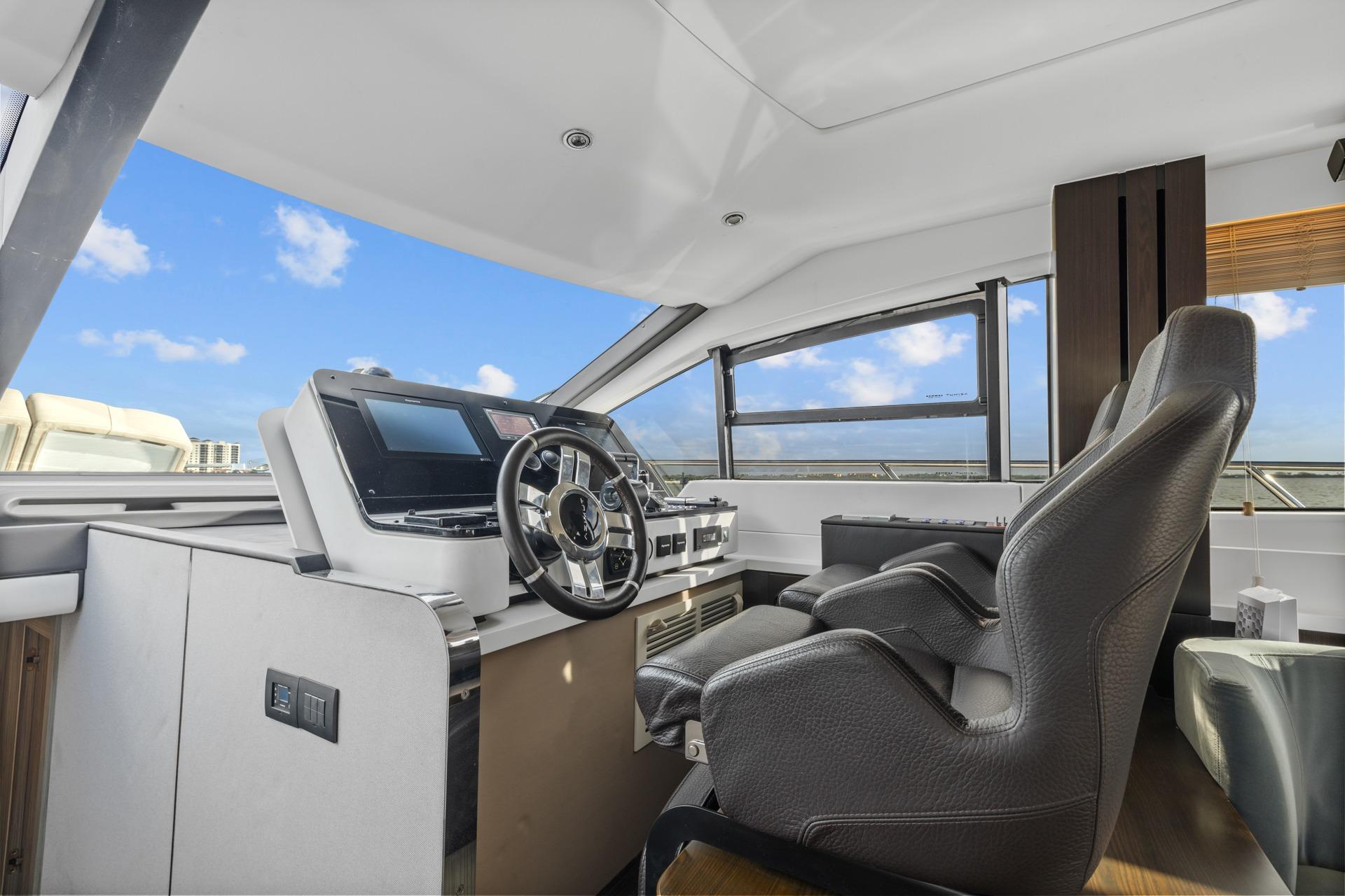 Luxurious 2019 Azimut 55 yacht helm with modern controls and panoramic windows.