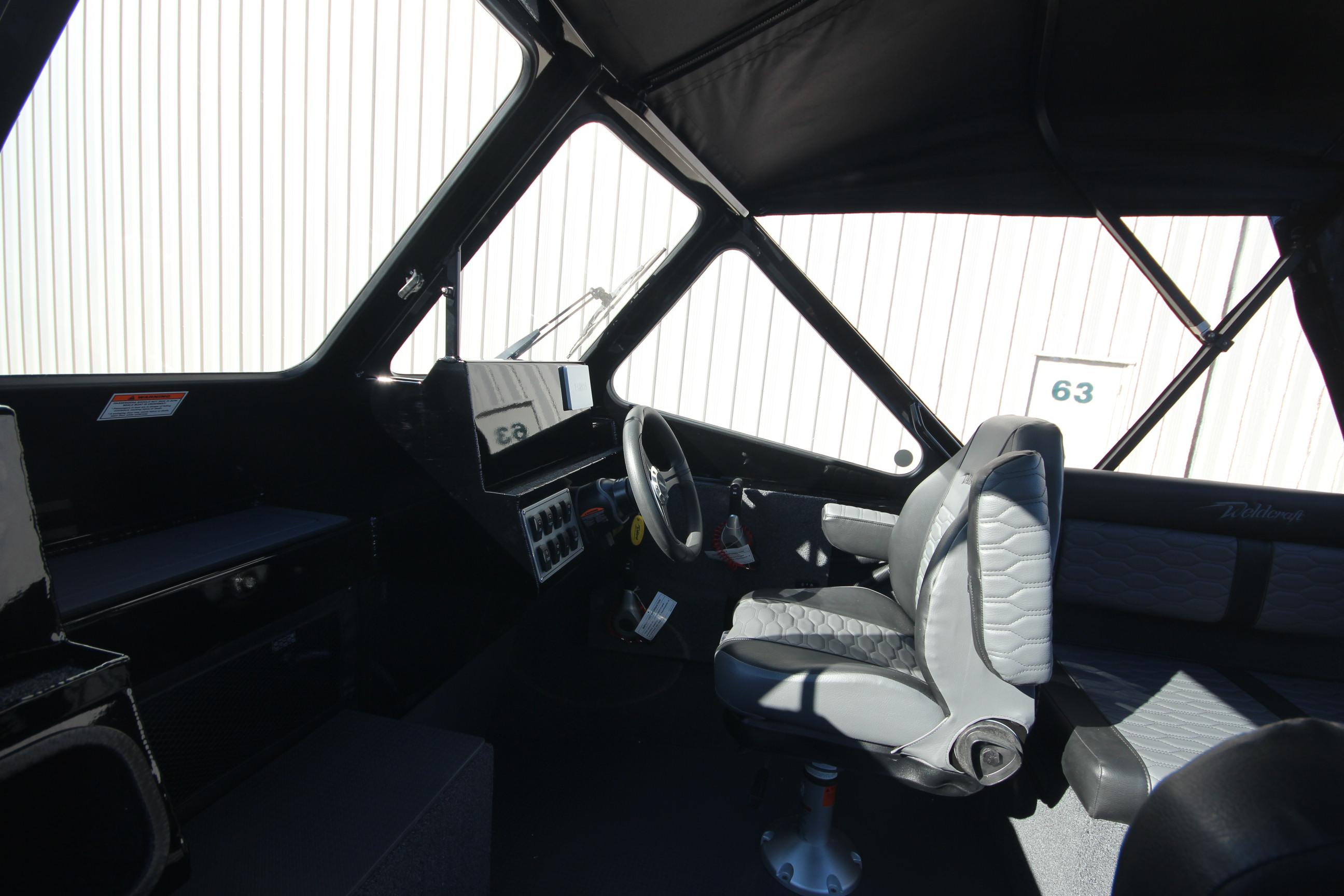 2025 Weldcraft 210 Revolution Soft Top boat interior with steering wheel and seating.