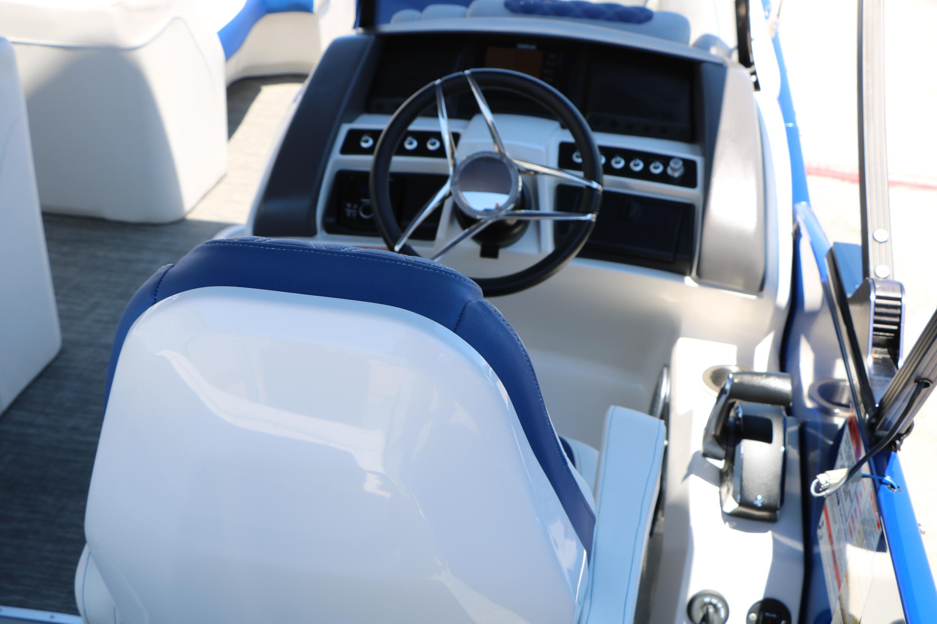 2024 Bennington 23 RX Swingback boat cockpit with steering wheel and controls.