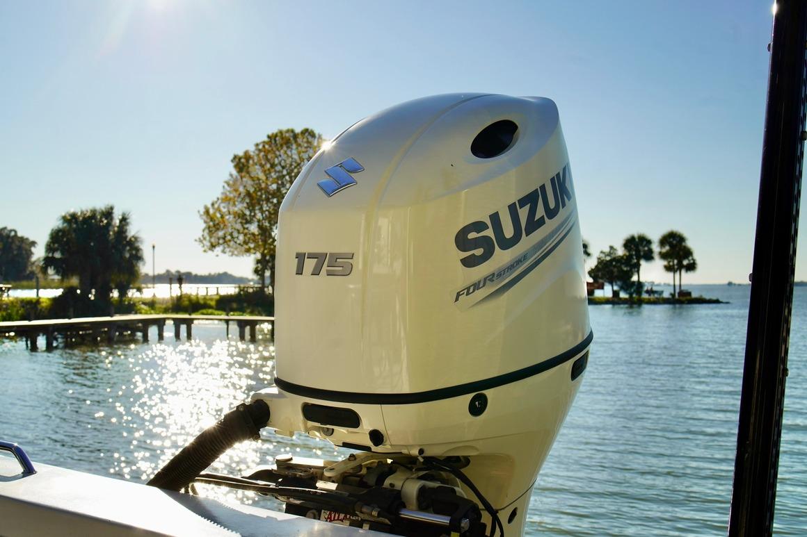 1970 Aquasport 222 Flatback with Suzuki 175 outboard motor on a sunny lake.