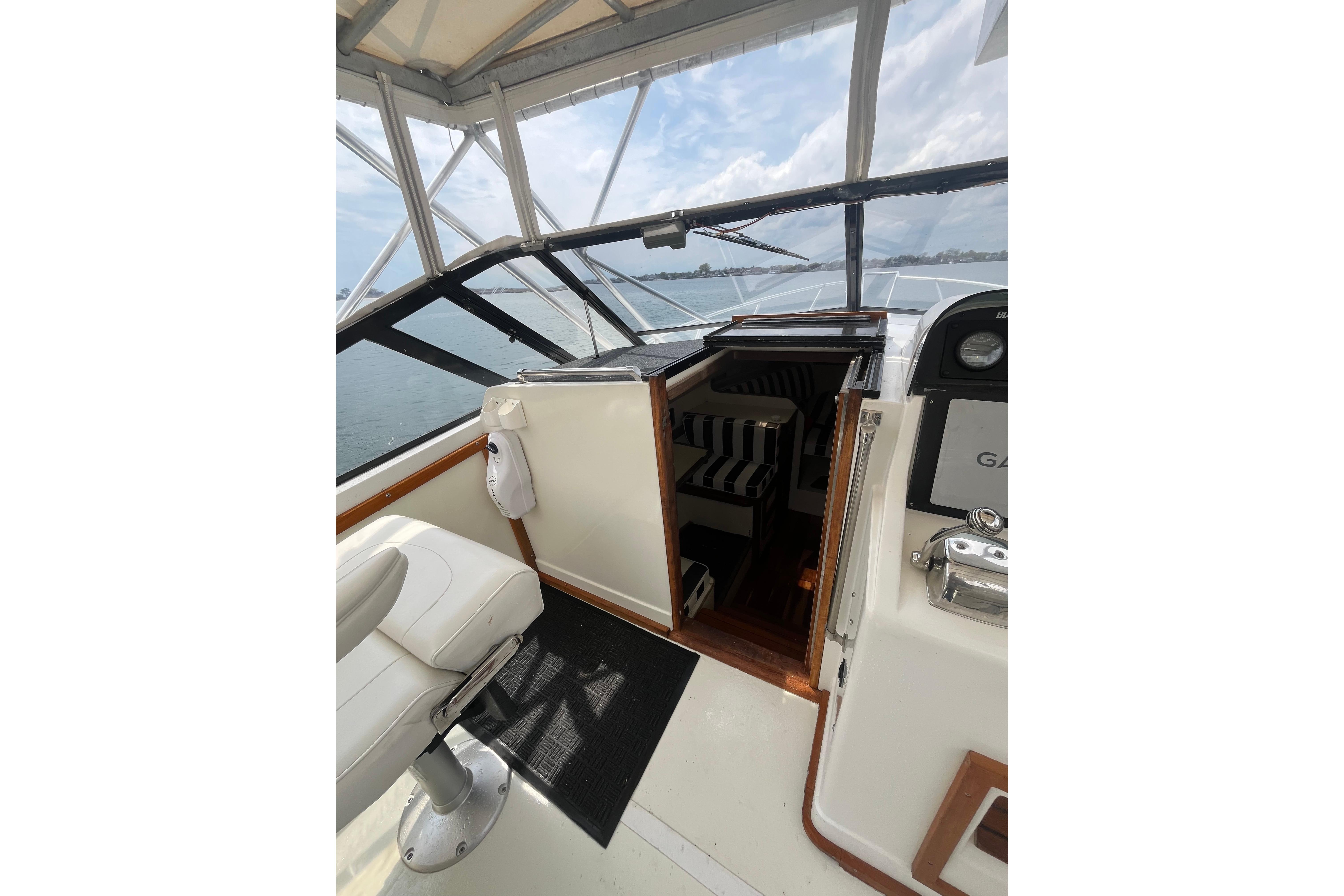 1989 Blackfin 31 Combi boat interior with helm, seating, and open cabin view.