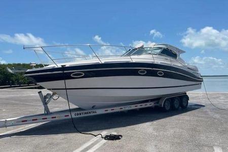 2007 Four Winns V338 boat on trailer under clear blue sky.