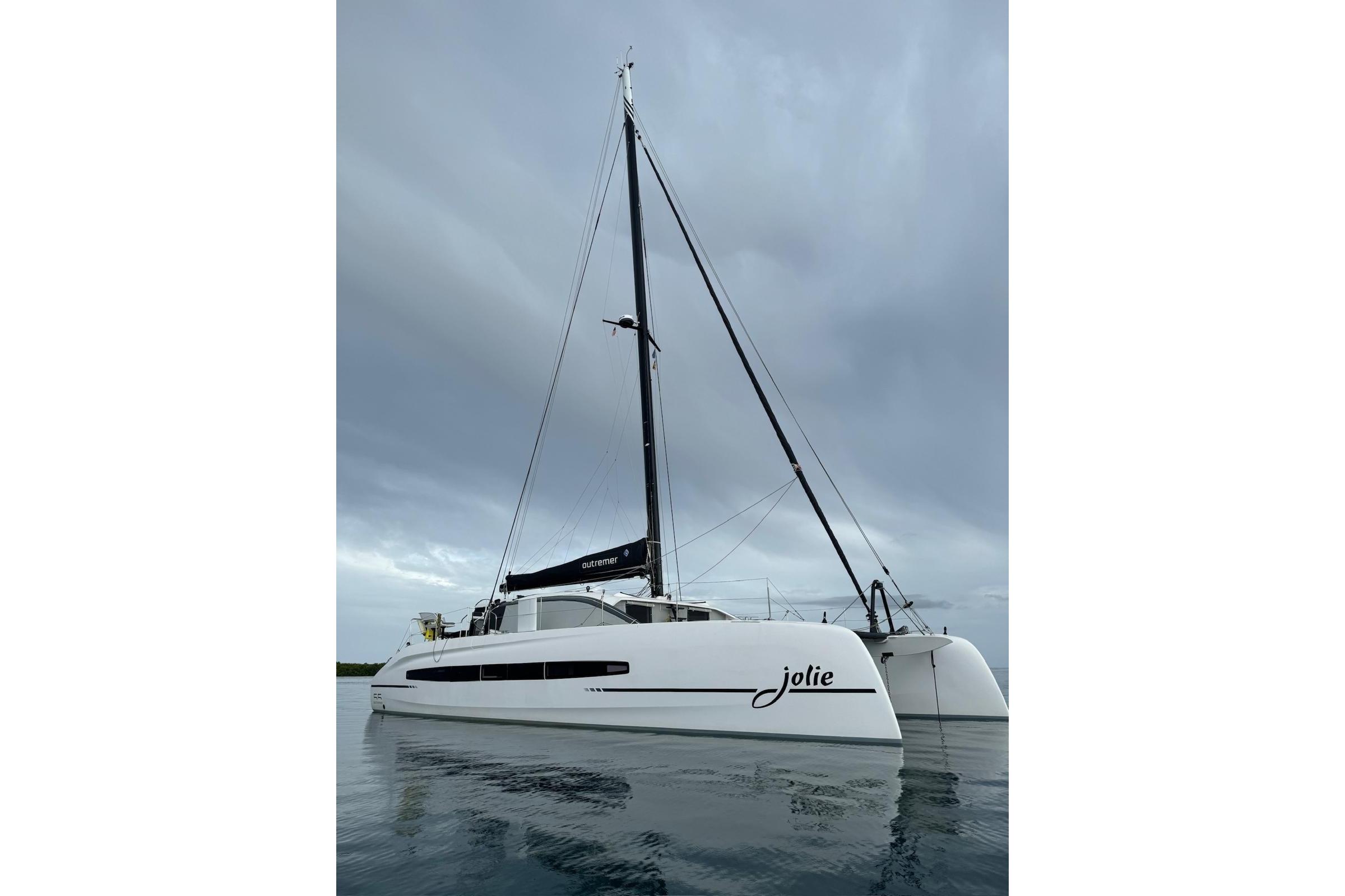 Outremer 55 catamaran 2022 on calm water under cloudy sky.