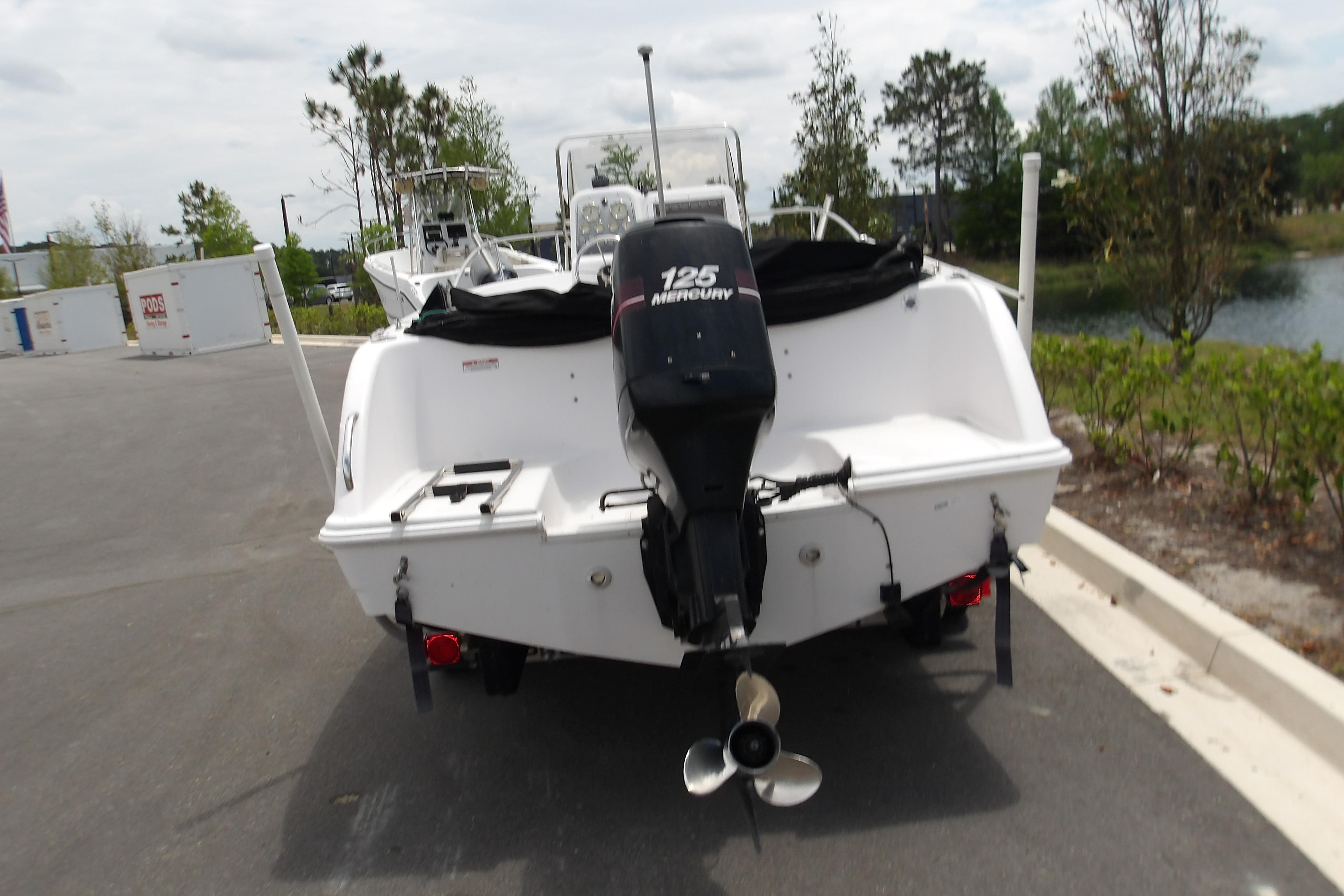 2000 Pro-Line 19 Sport boat with Mercury 125 engine, parked outdoors.
