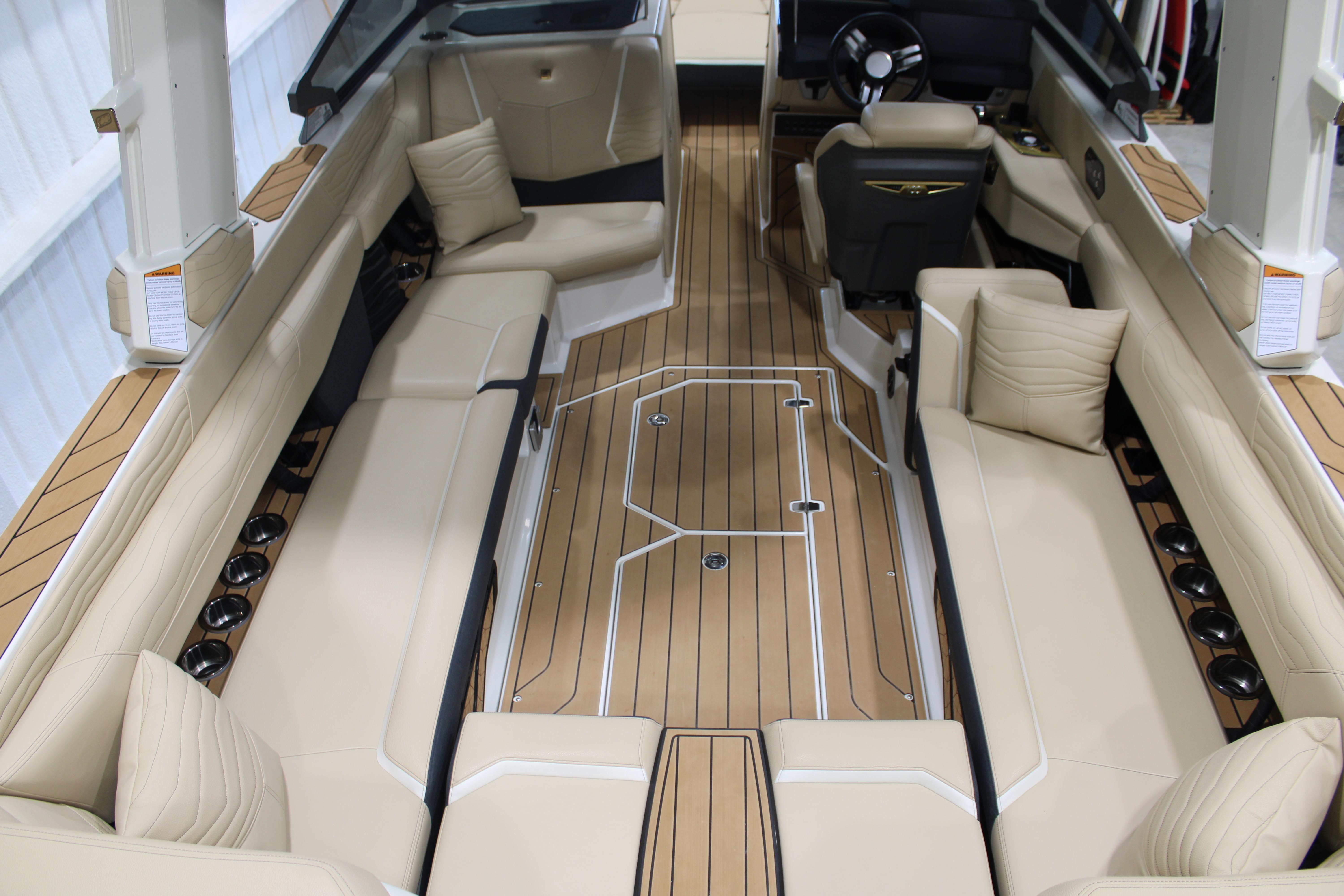 2025 Nautique Super Air Nautique G25 interior with beige seating and wood flooring.