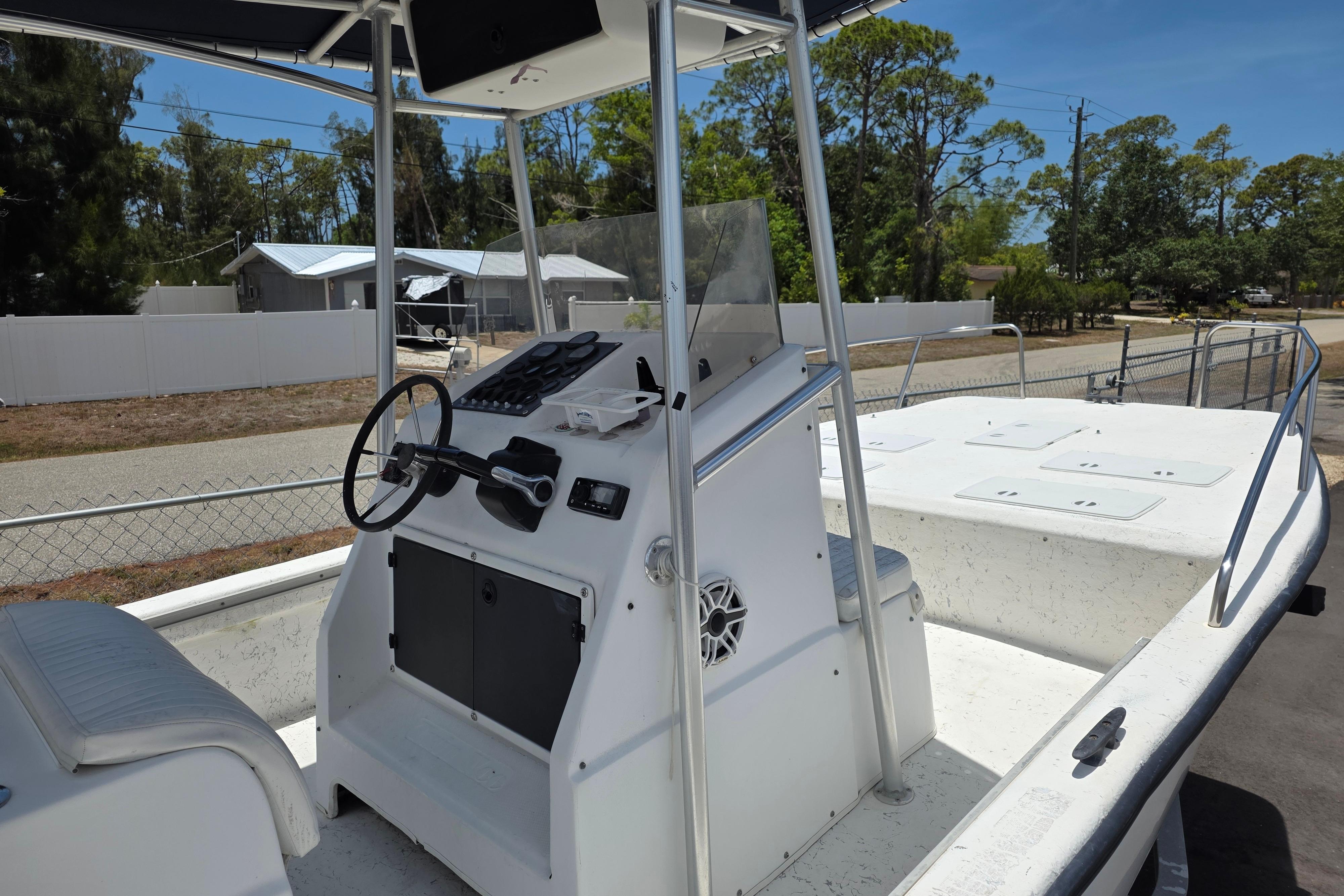 1999 Twin Vee Awesome 22 boat with center console and steering wheel, parked outdoors.