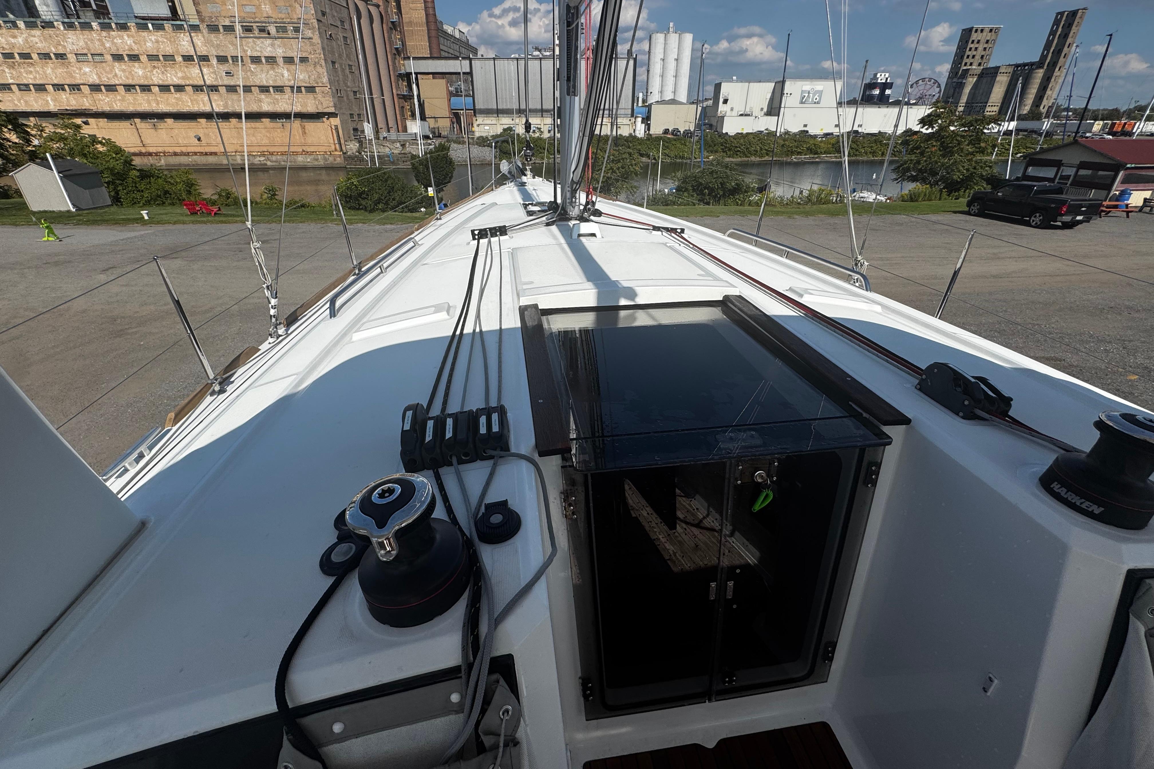 2023 Beneteau Oceanis 38.1 sailboat deck with urban industrial backdrop.