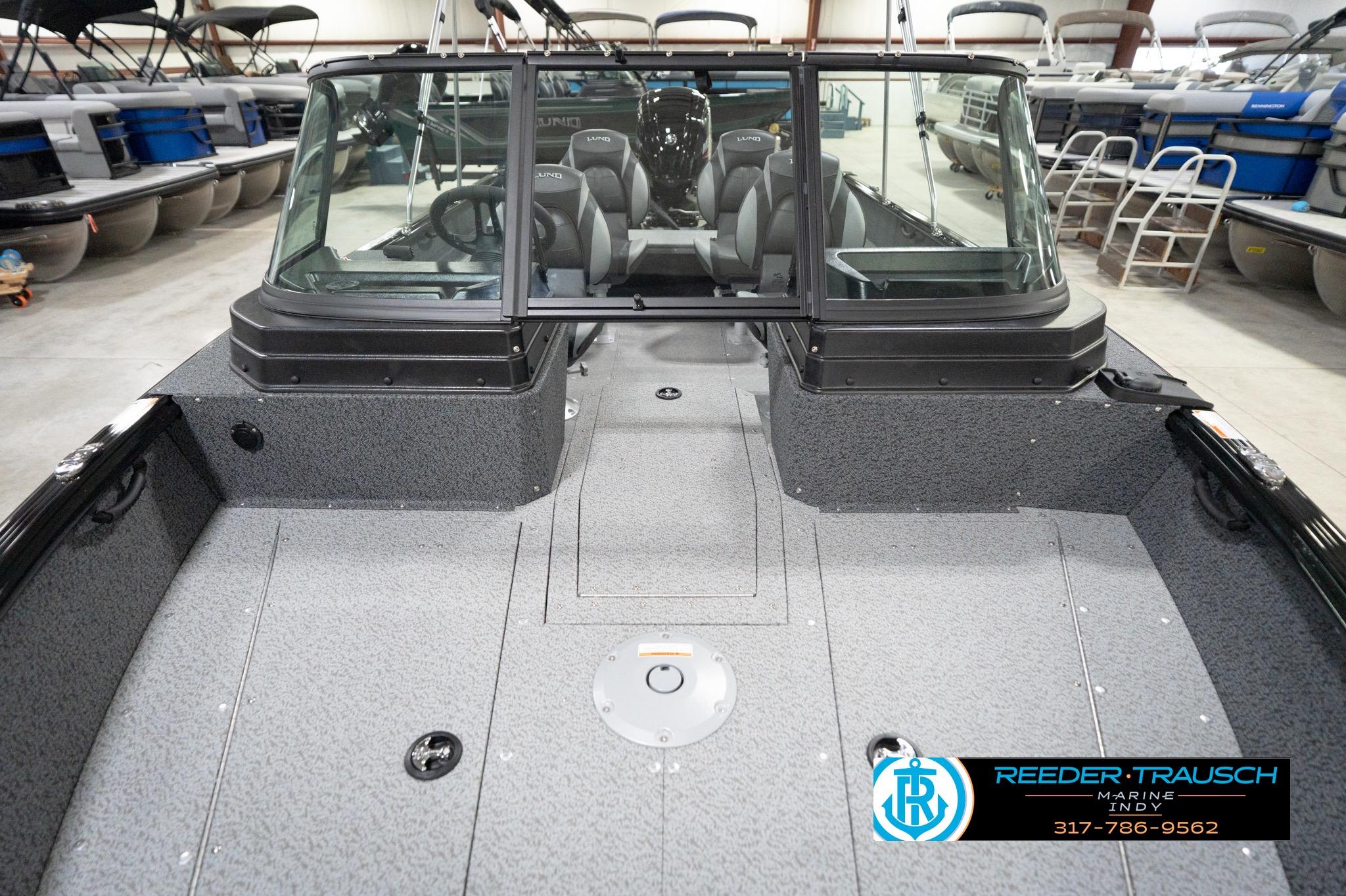 2026 Lund 1800 Explorer Sport boat interior in showroom, featuring spacious seating and modern design.