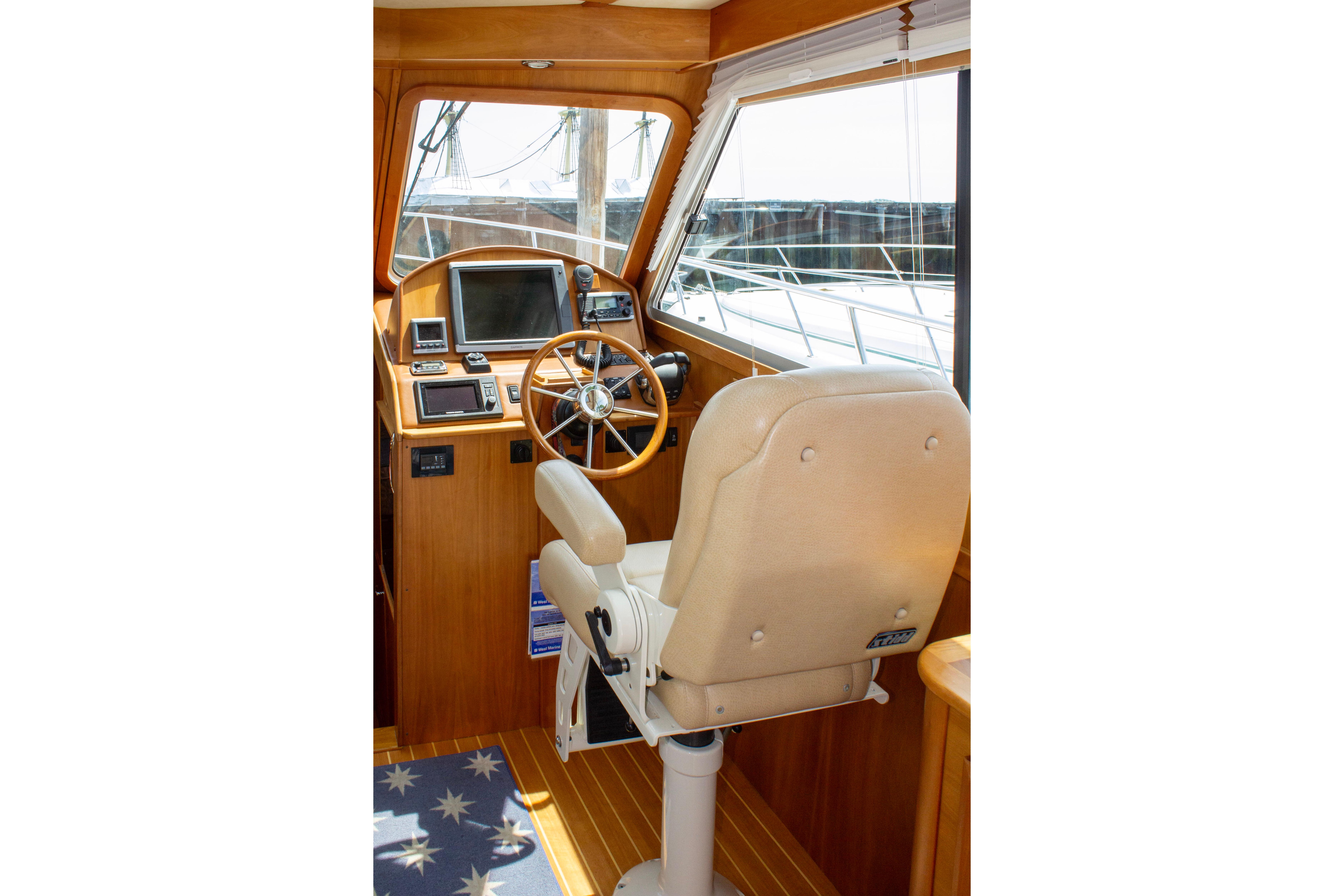 Helm of 2013 Sabre 38 Salon Express with wooden steering wheel and navigation equipment.