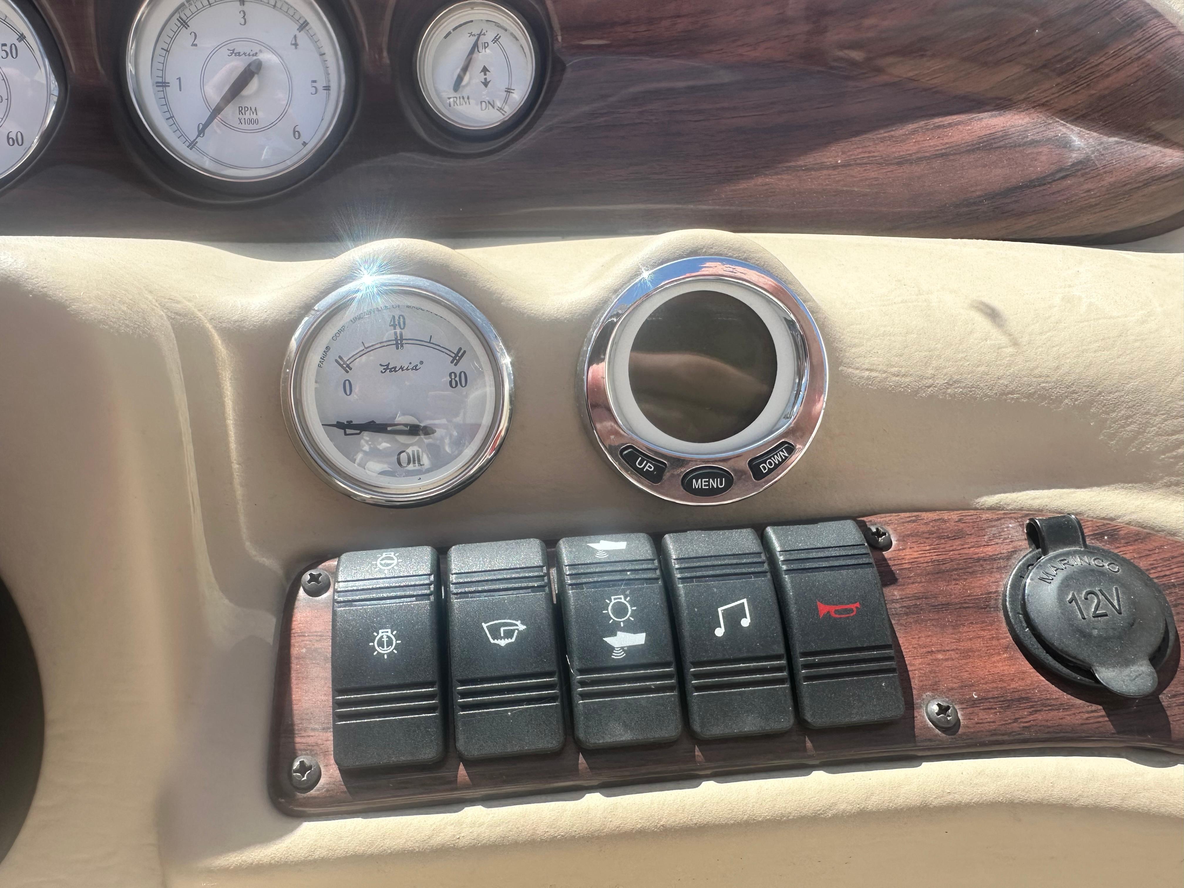 Dashboard of a 2008 Glastron 205 GX boat with gauges and control switches.