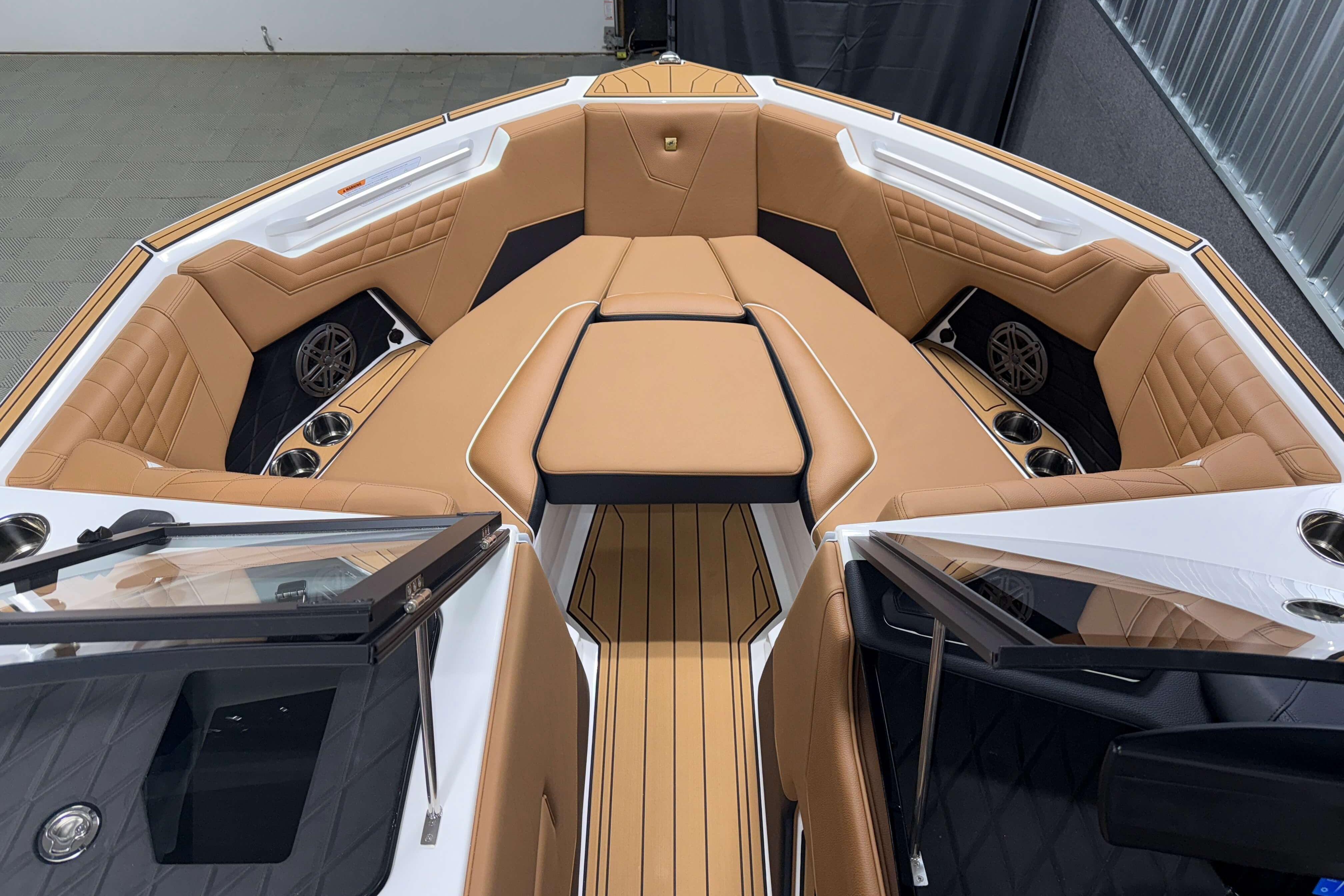 2026 Nautique Super Air Nautique S23 boat interior with tan leather seating and cup holders.