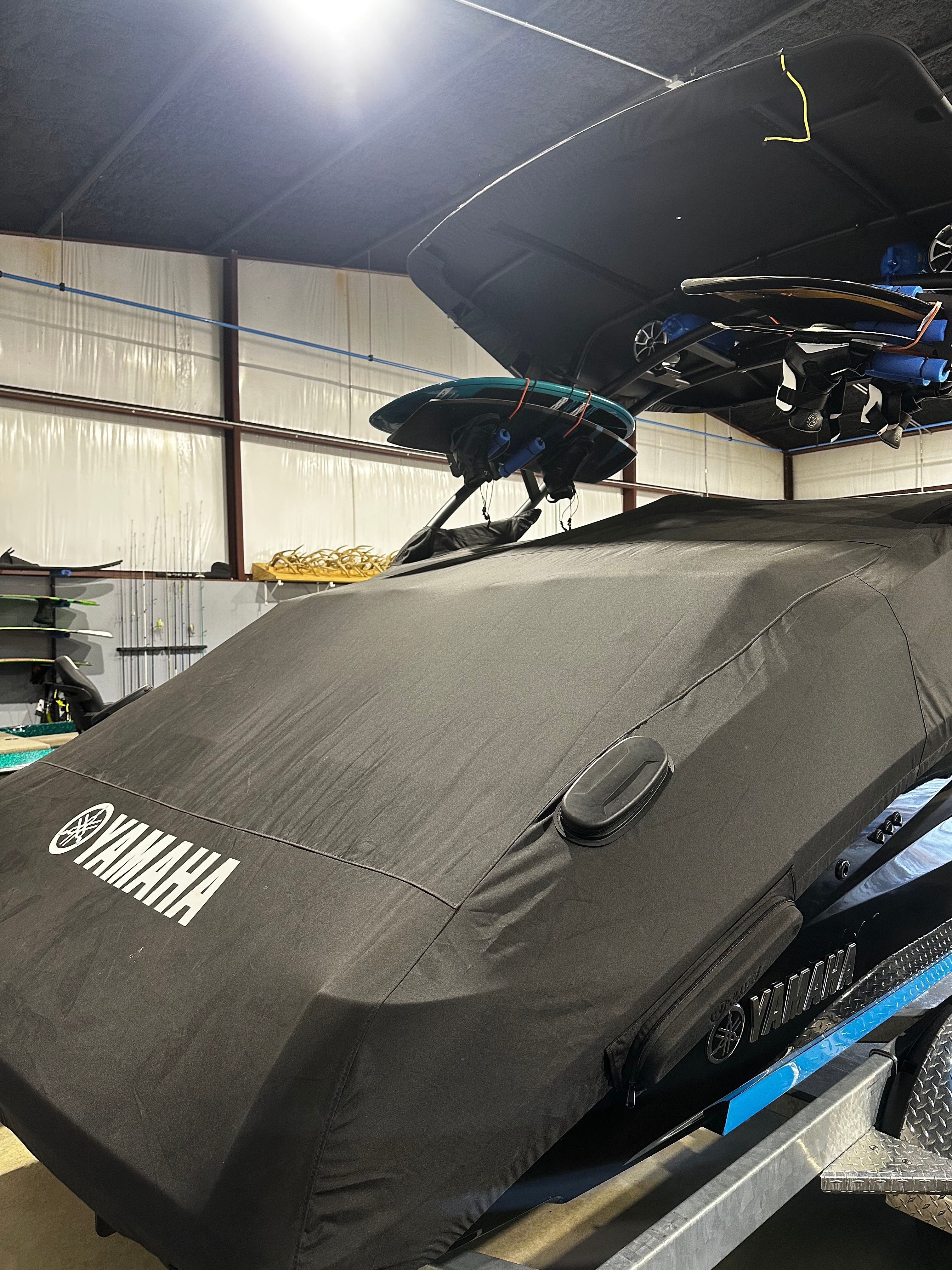 2023 Yamaha Boats 255XD covered in a garage, showcasing sleek design and storage features.