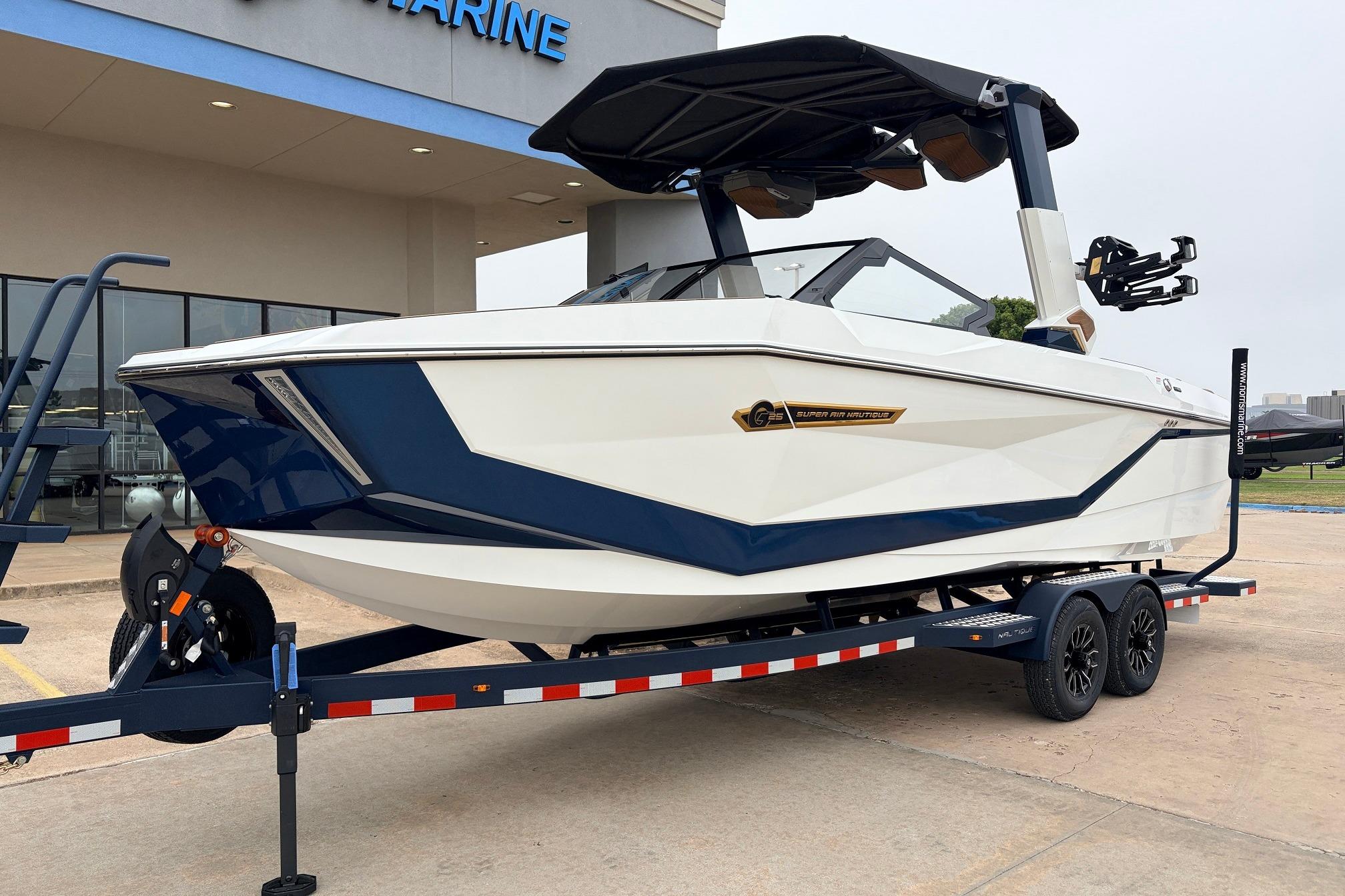 2026 Nautique Super Air Nautique G25 boat on trailer, displayed outside a marine dealership.