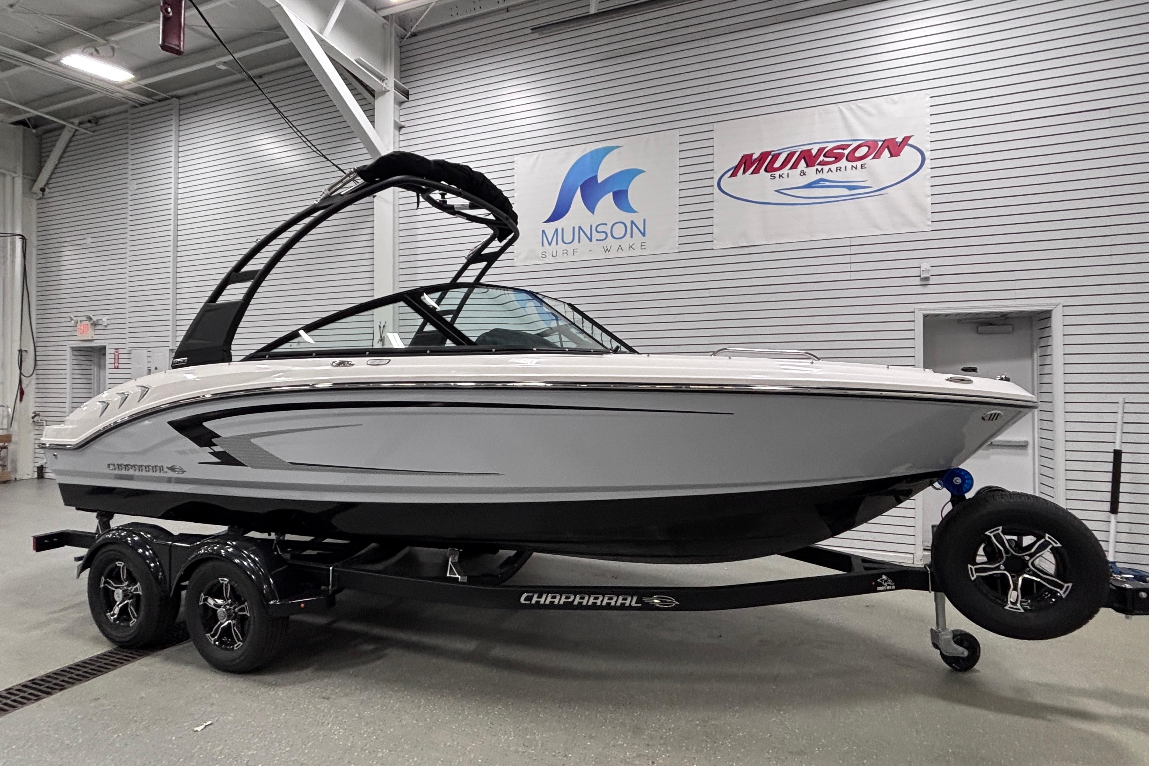 2026 Chaparral 21 SSi boat on trailer in showroom, Munson Ski & Marine signage visible.