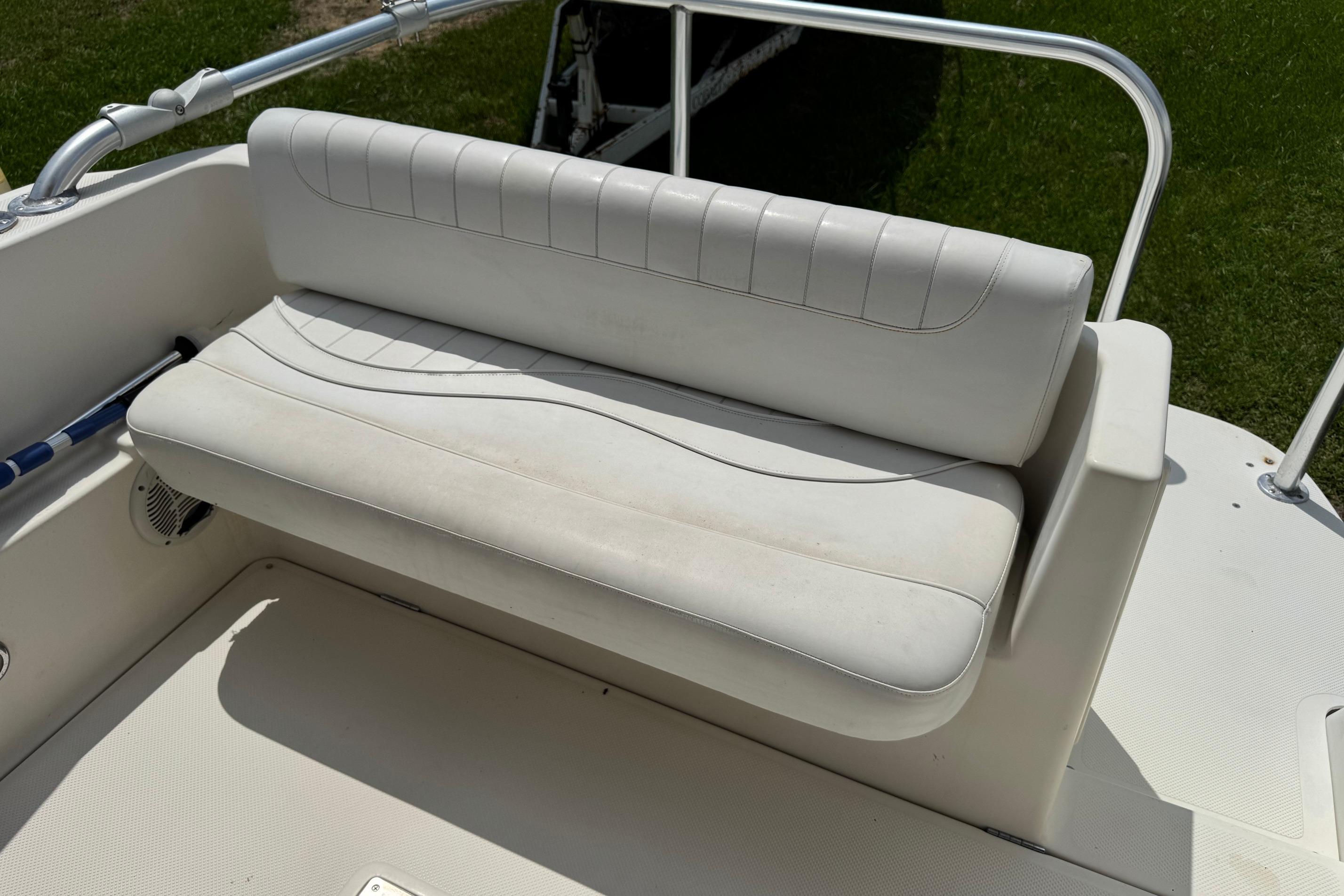 White seating area on a 2000 Maxum 2400 SCR boat, featuring sleek design and railing.