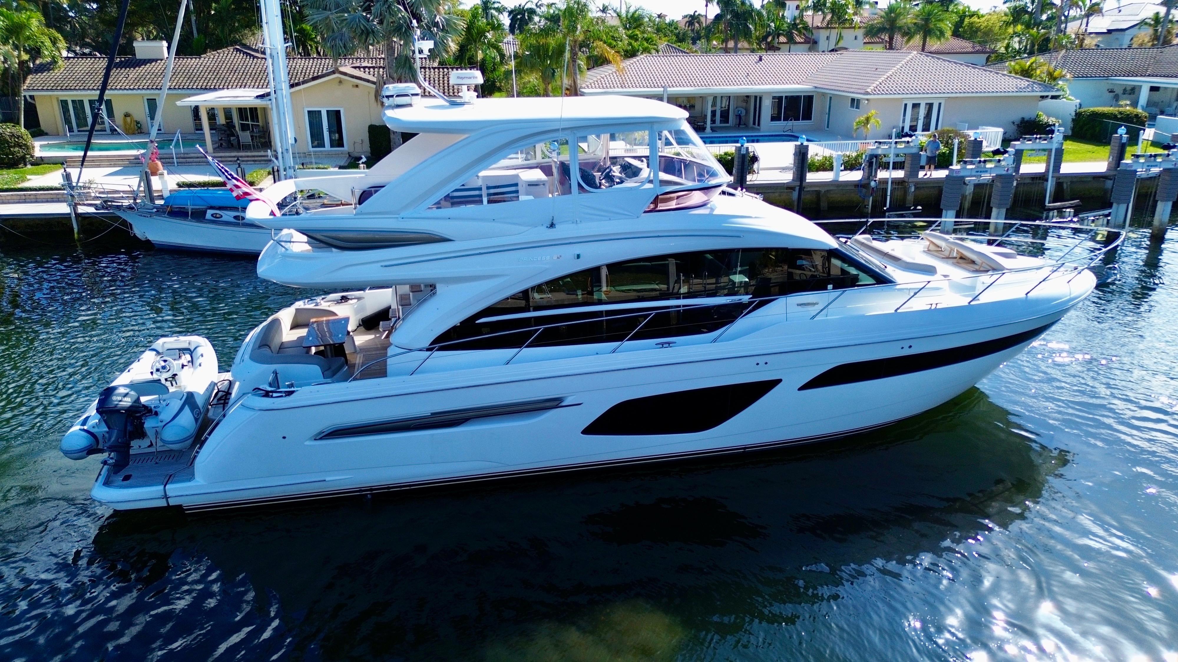 Luxurious 2019 Princess F62 yacht docked in a serene waterfront setting.