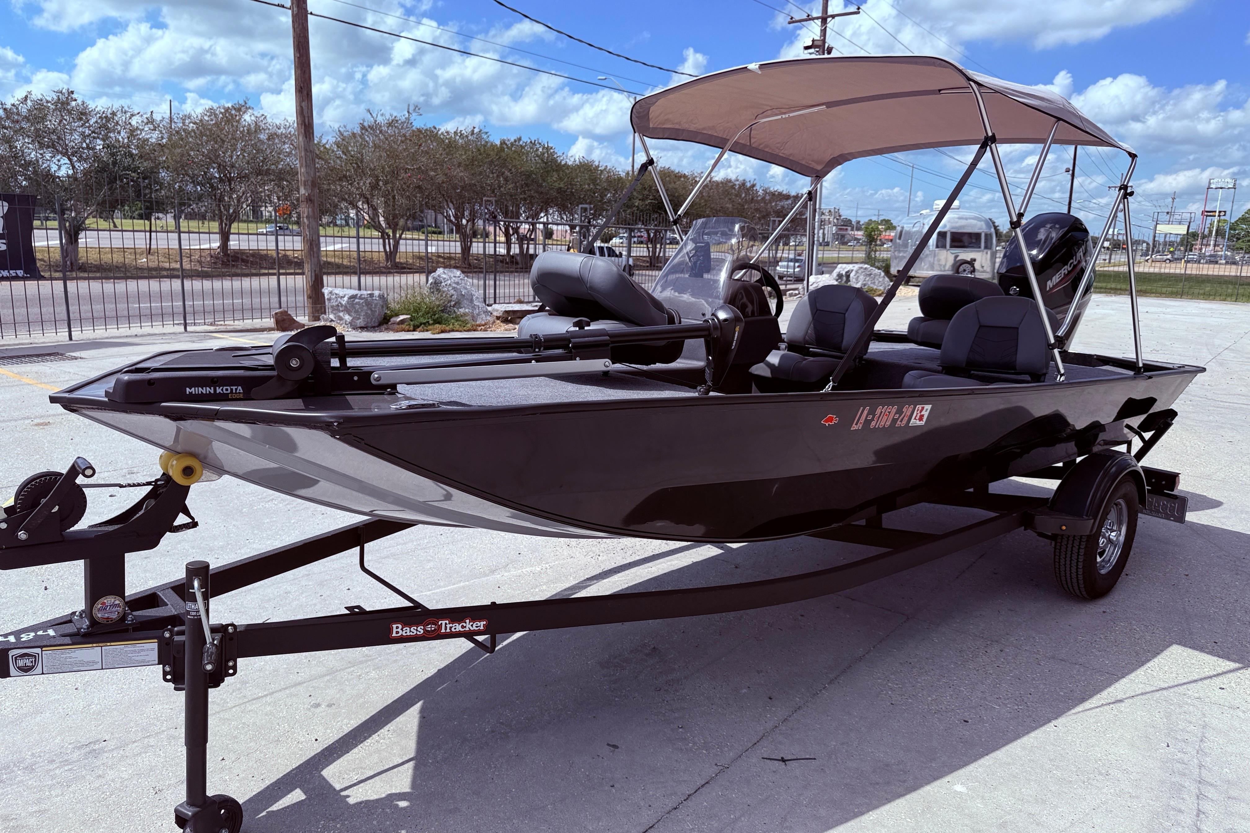 2025 Bass Tracker Classic XL boat with canopy on trailer, parked outdoors.
