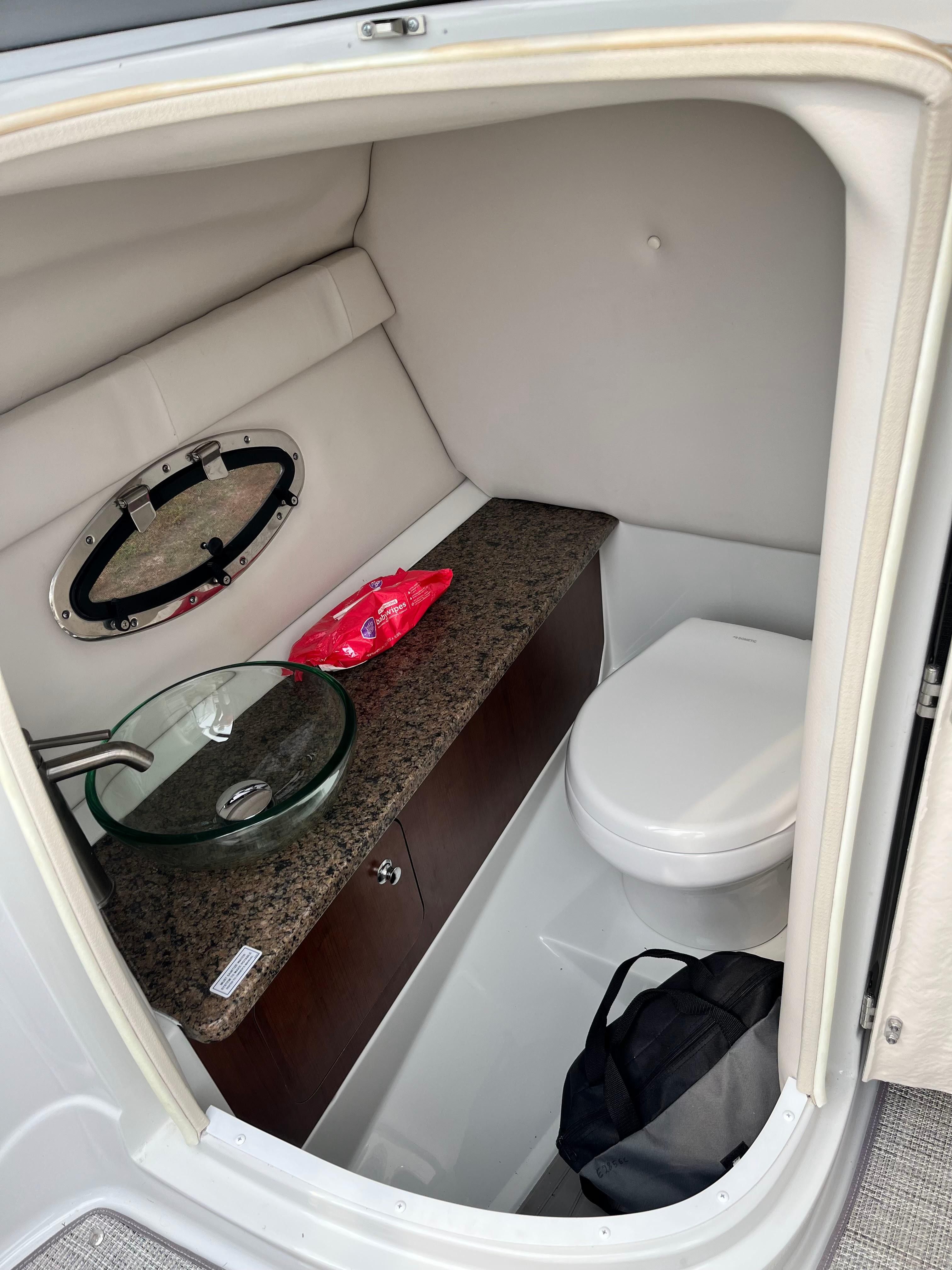 Interior of a 2019 Crownline E 285 featuring a toilet and sink.