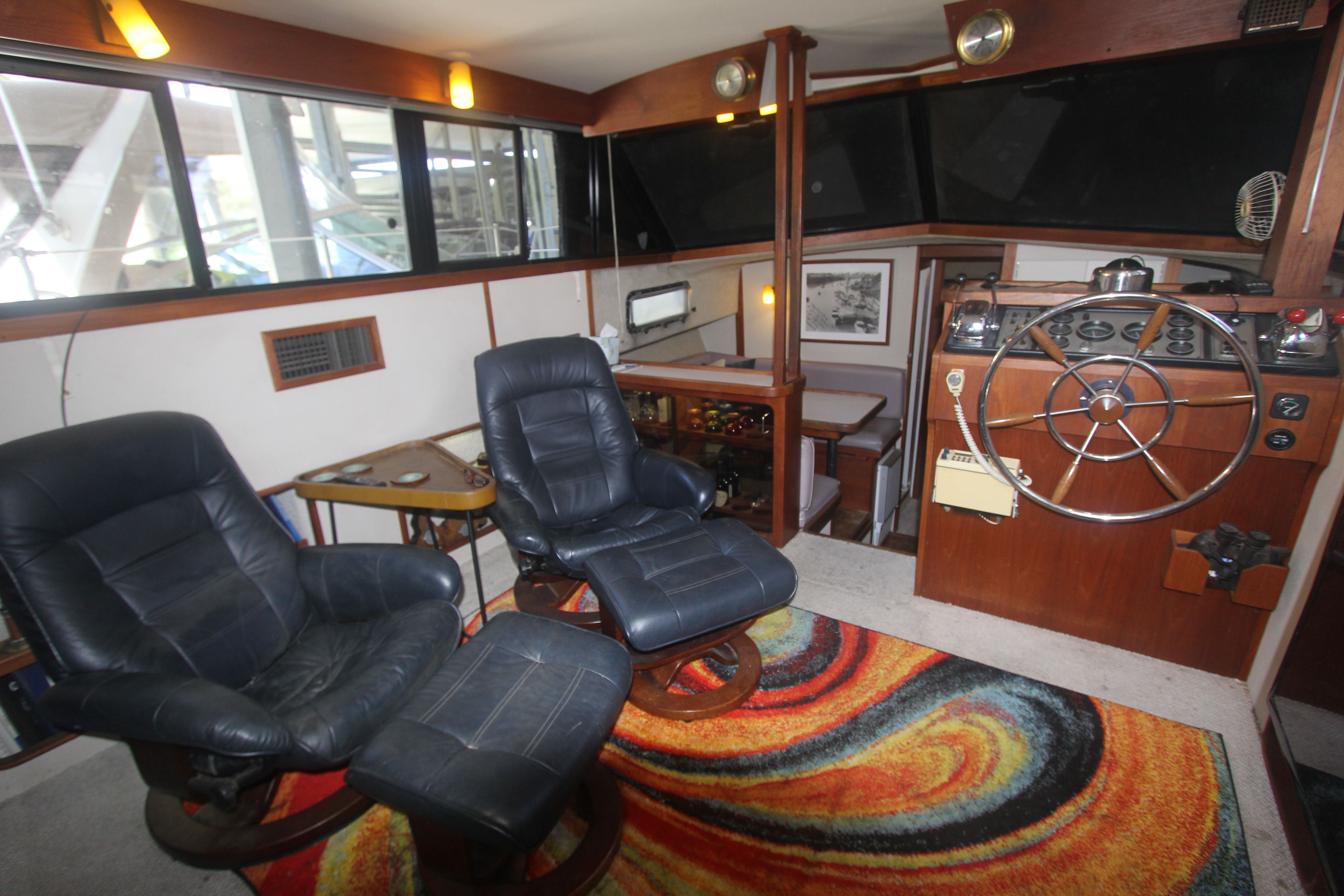 Interior of the 1988 Carver 3607 Aft Cabin Motor Yacht with leather chairs and steering wheel.