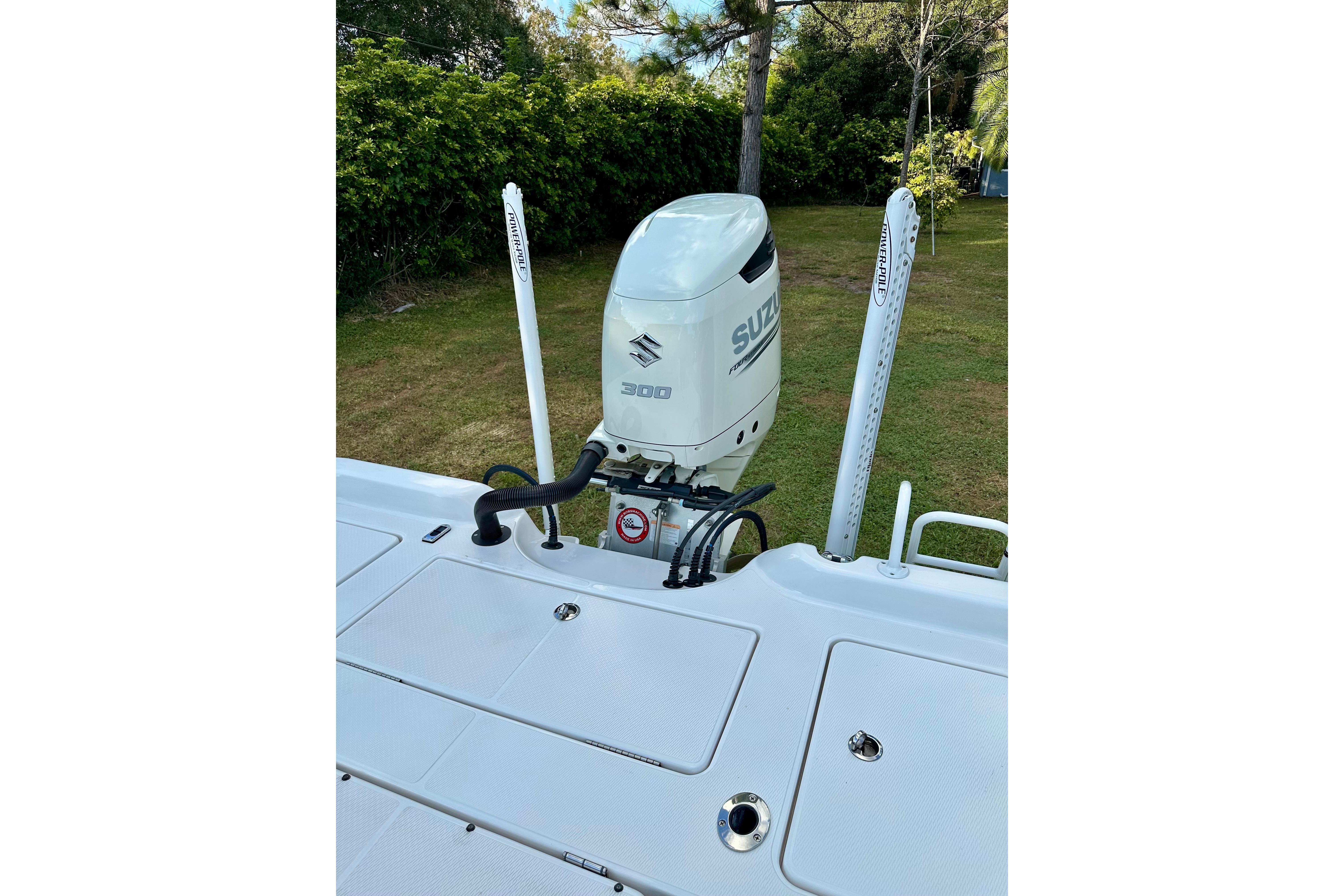 2017 Blue Wave 2400 PureBay boat with Suzuki 300 outboard motor, in a grassy area.