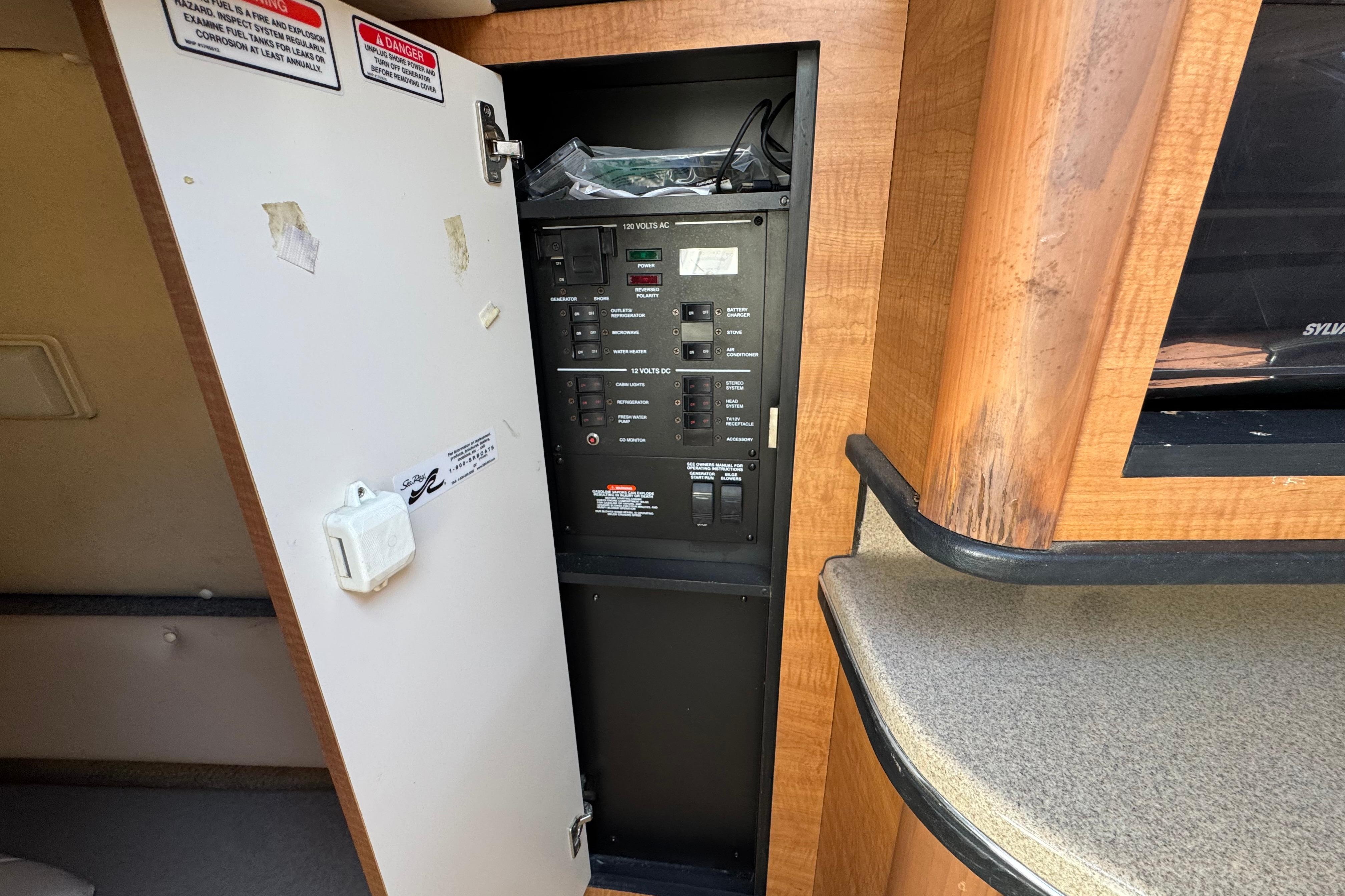 Electrical panel inside 2006 Sea Ray Sundancer 260 boat cabin with open door.