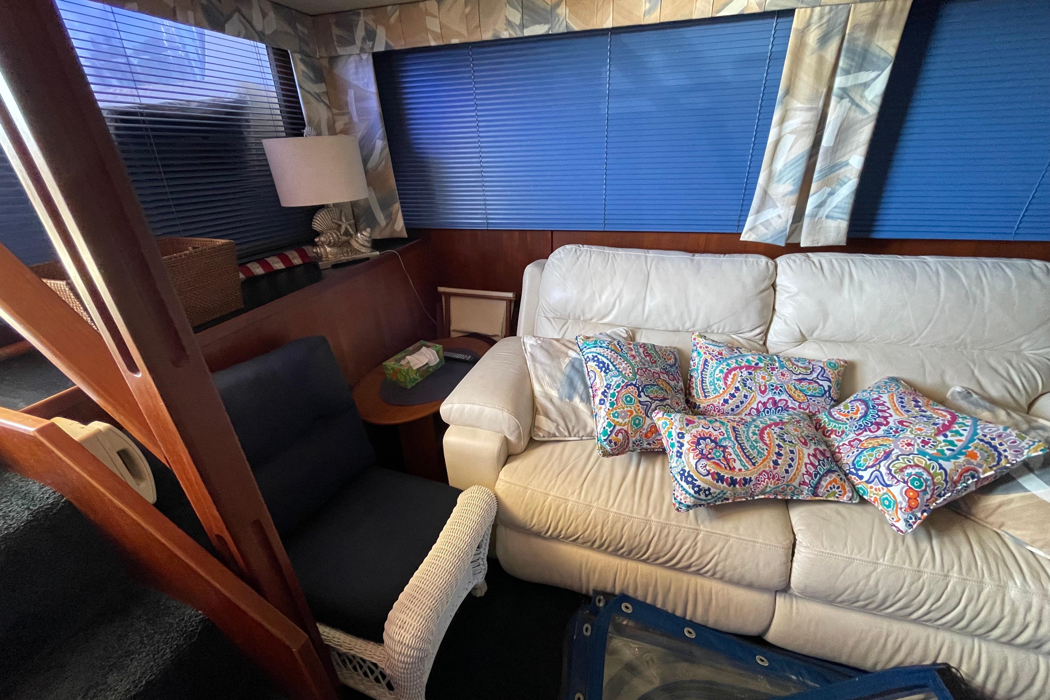Interior of 1985 Chris-Craft 426 Catalina with white sofa and colorful cushions.