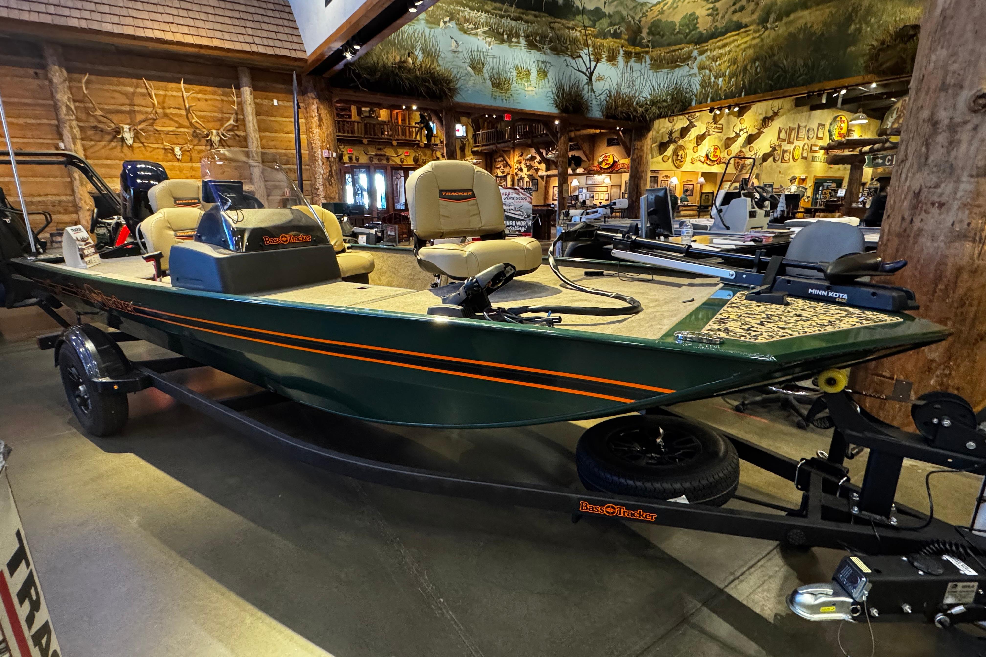 2026 Tracker Bass Tracker Classic Limited boat displayed indoors with fishing equipment.