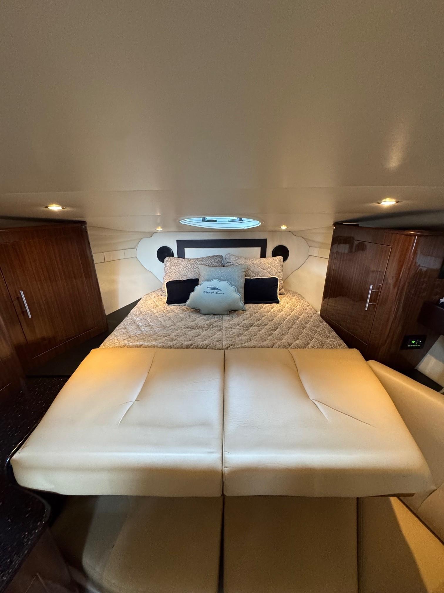 2014 Regal 32 Express cabin interior with bed, wooden cabinets, and ambient lighting.