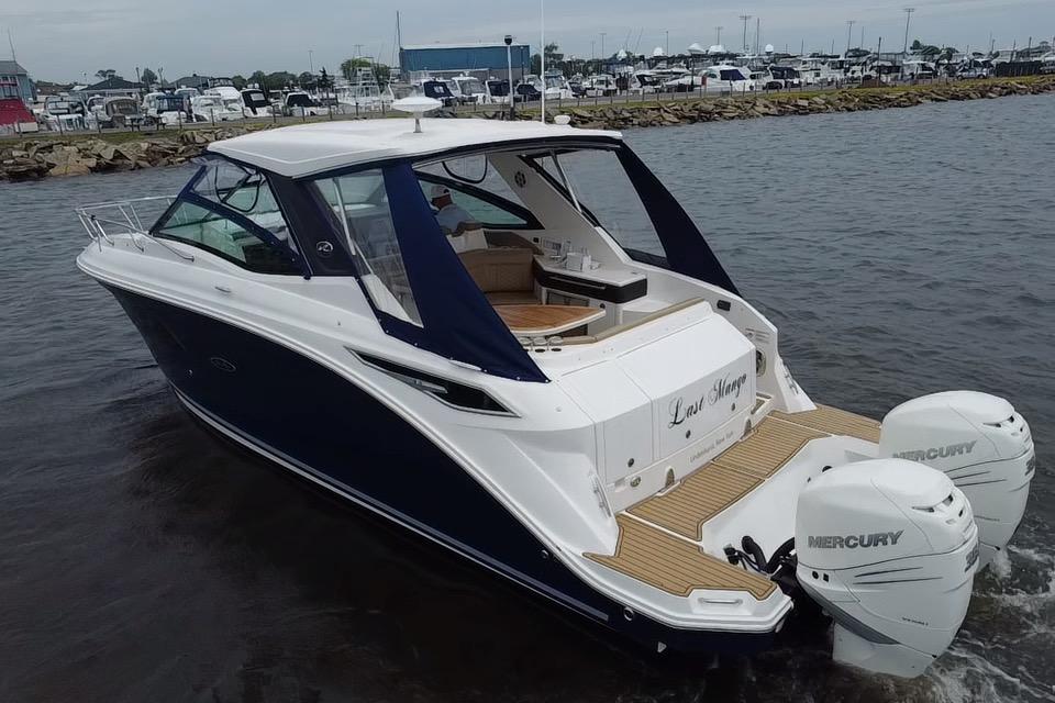 2021 Sea Ray Sundancer 320 Outboard cruising on water, featuring dual Mercury engines.