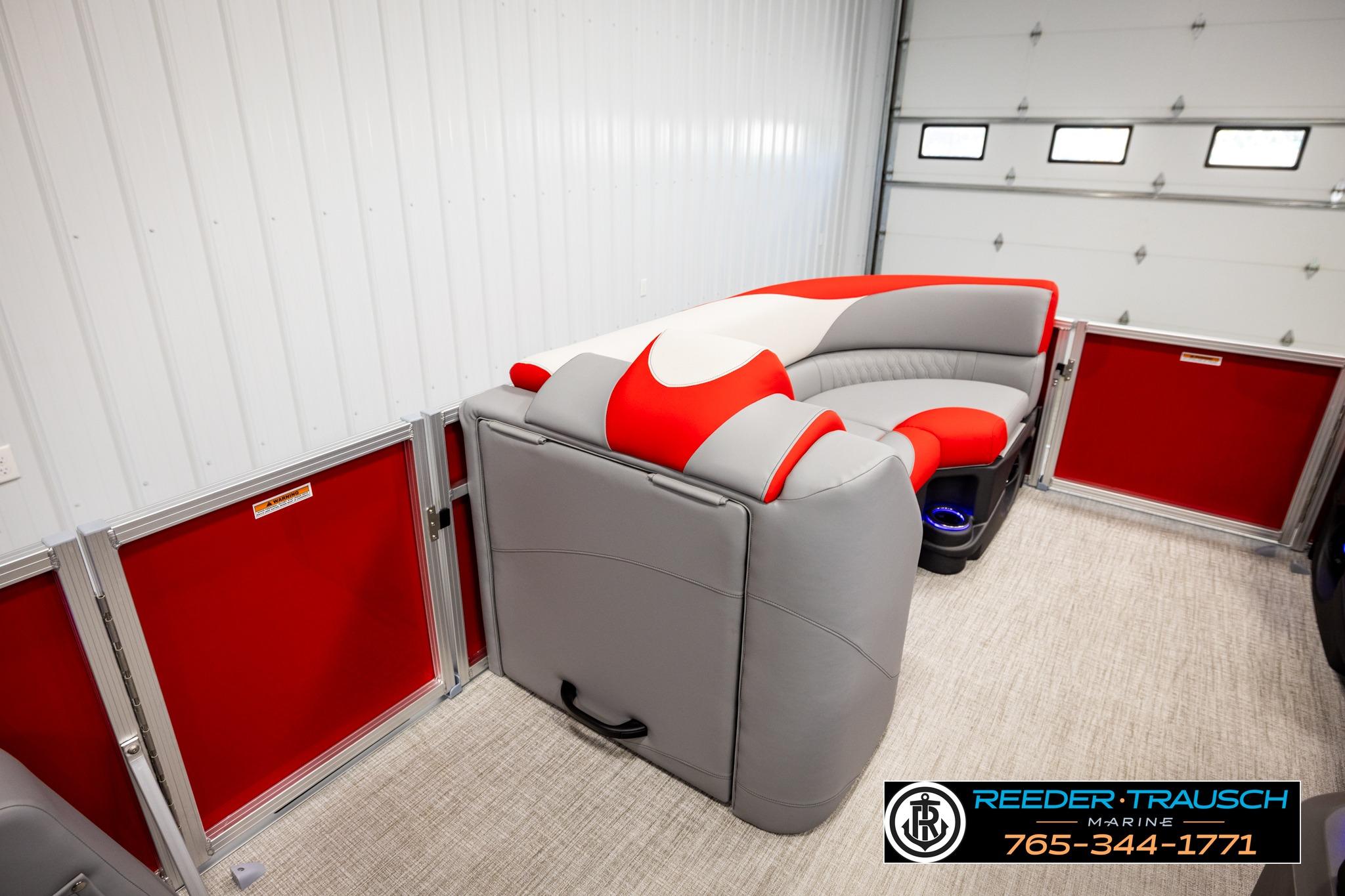 2026 Avalon LSZ QL pontoon boat interior with red and gray seating in a garage.